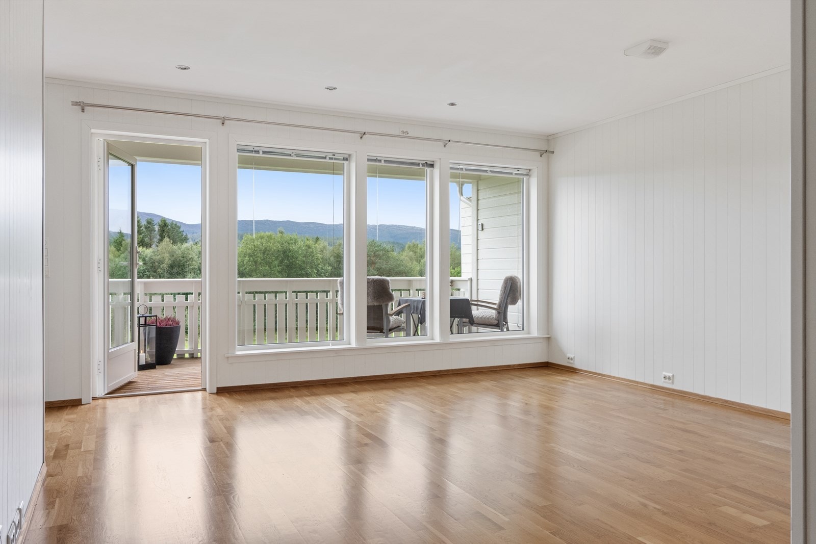 Åpen og lys stue med glassfasade i front. Galleribilde