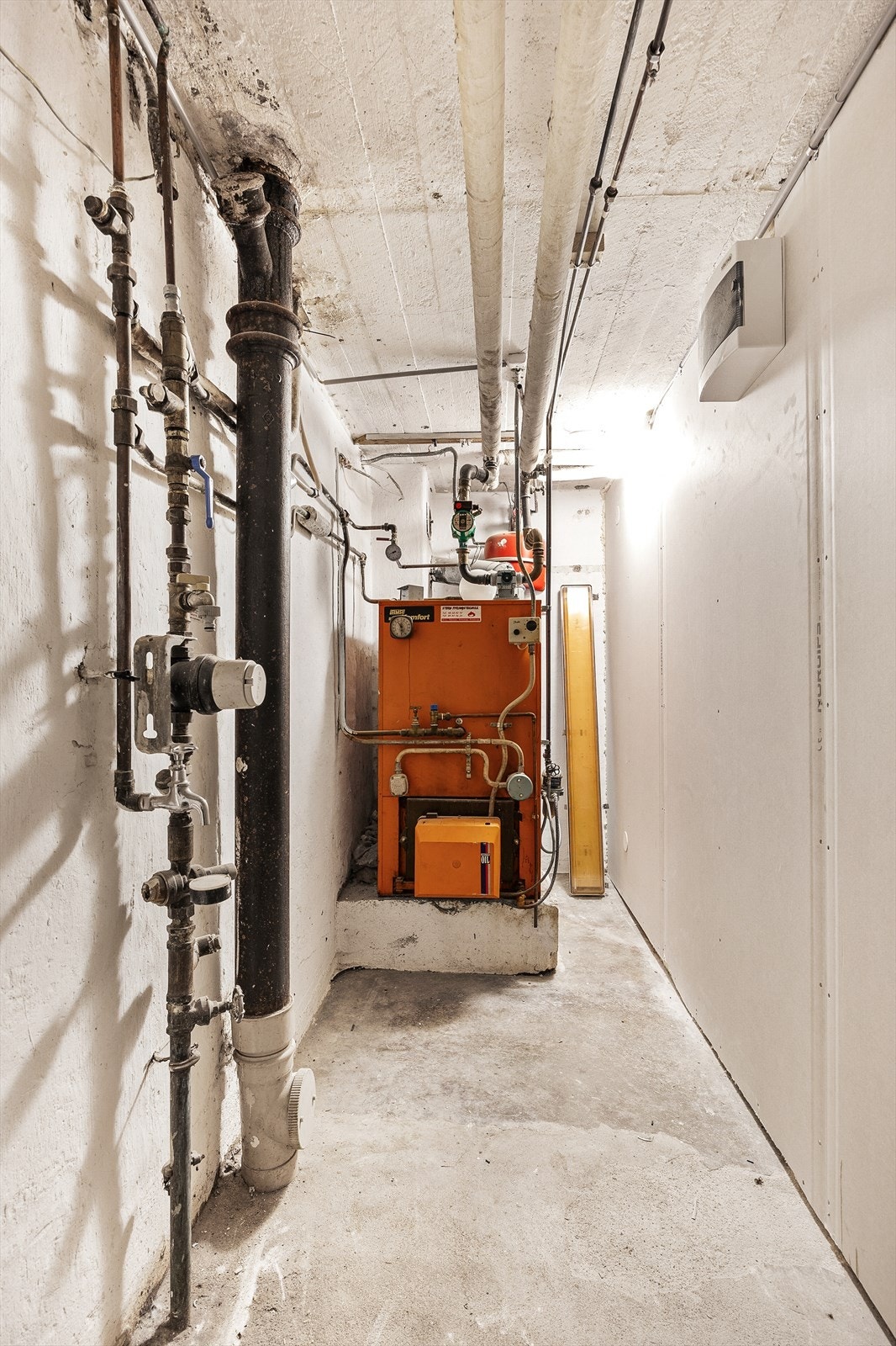 Her i kjelleren finner vi også boligens fyrkjele tilknyttet radiatorer, stoppekran og vannmåler. Galleribilde