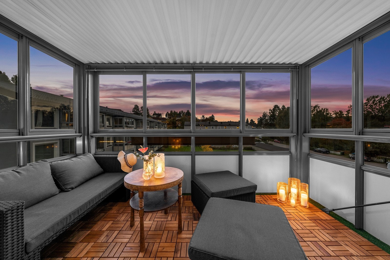 Innglasset balkong med pene trelemmer på gulvet og en flott utsikt gir et hyggelig uterom året rundt. Galleribilde