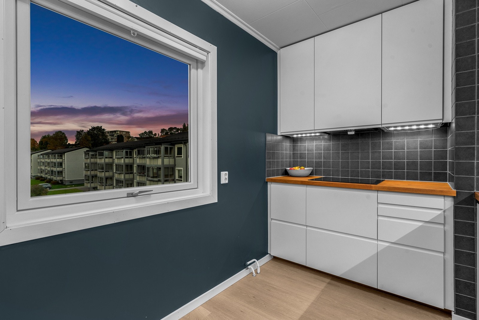 Fliser mellom benkeplate og høyskap gir en praktisk og lettstelt vegg, med god arbeidsflate for matlaging. Galleribilde