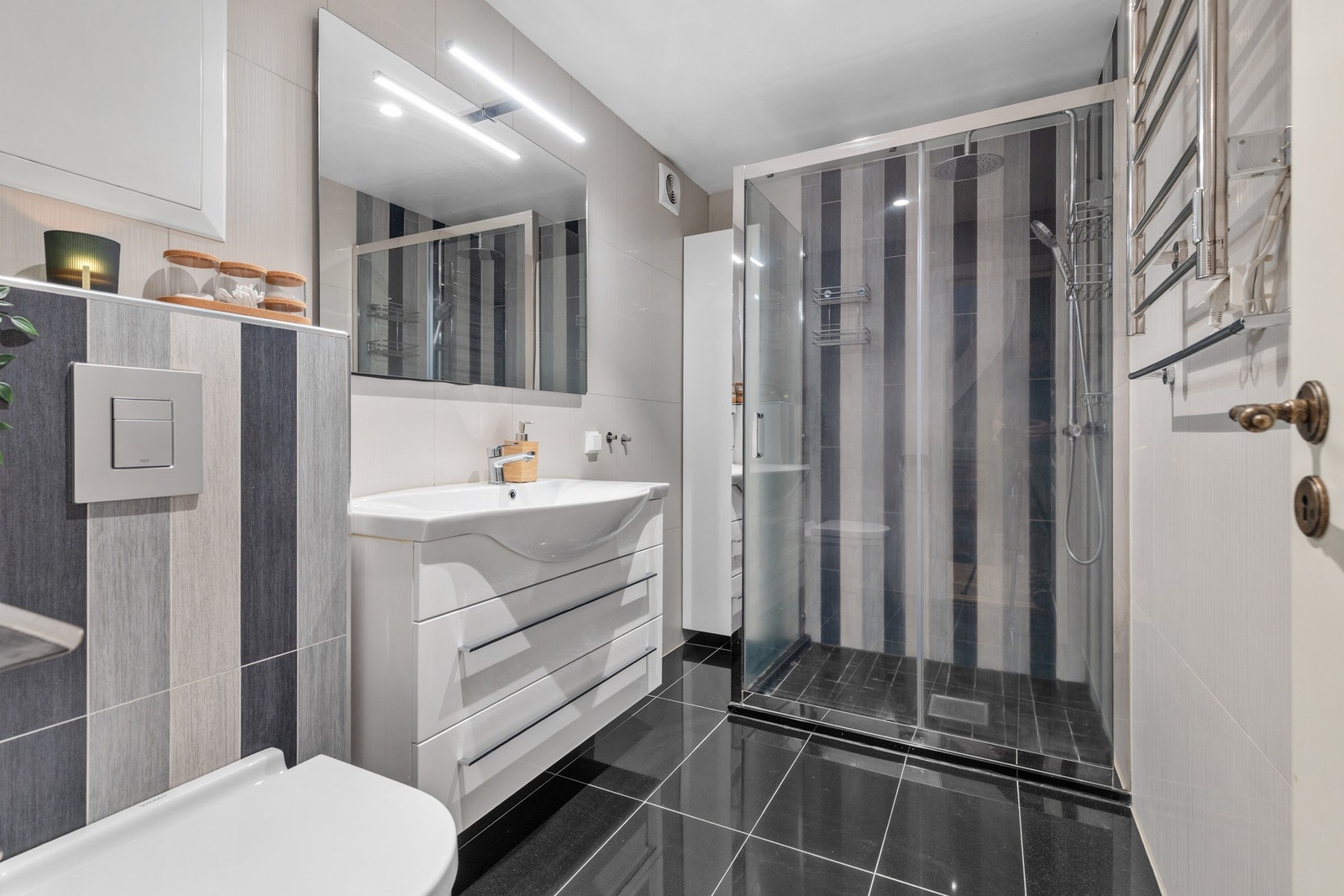 Pent, helfliset bad fra 2016 med dusjnisje med dusjarmatur og skyvedører samt vegghengt servant med ettgreps blandebatteri og speil med overlys. Her er det også gulvvarme. Galleribilde