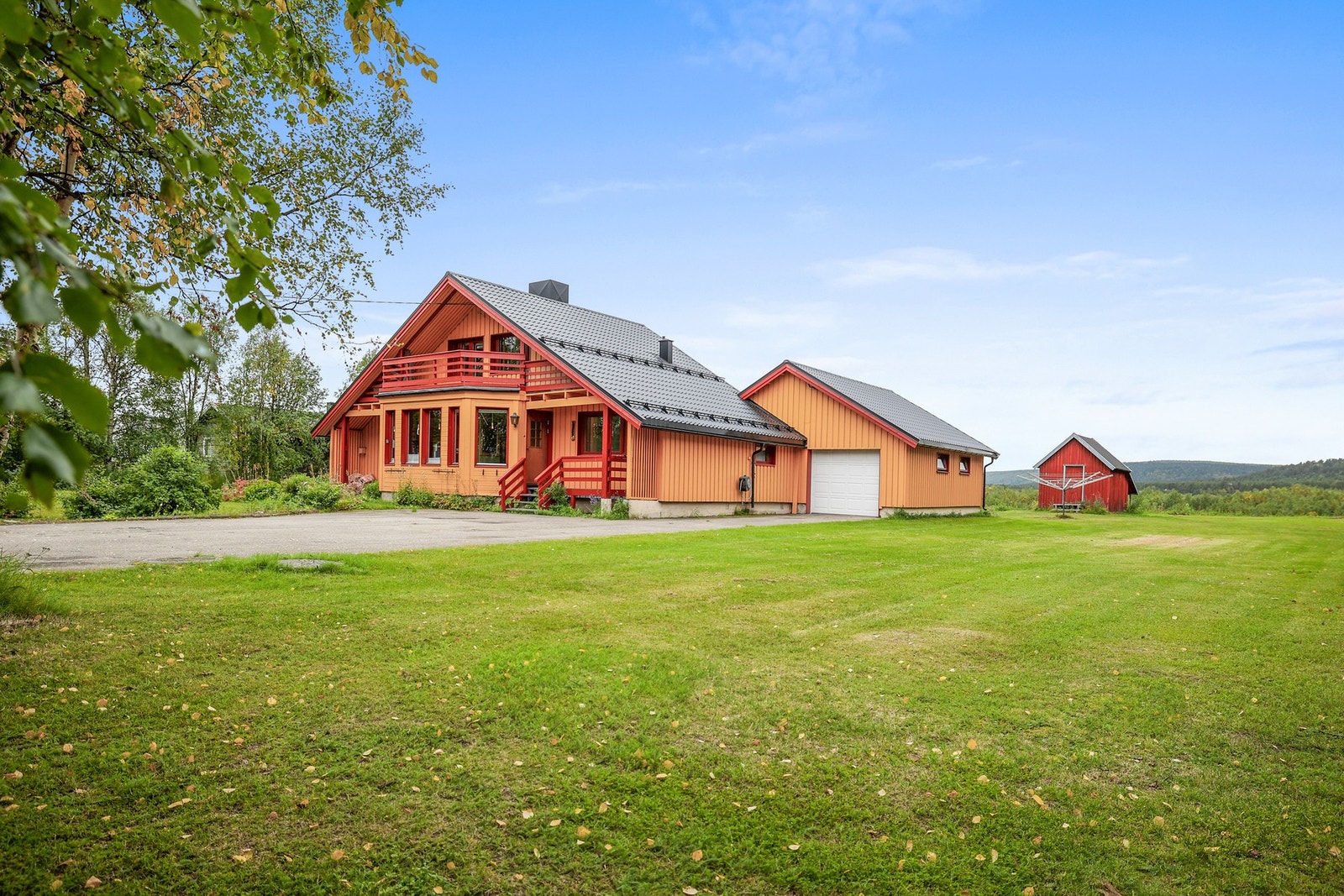 Tomten en relativt flat. Den er opparbeidet med plen, beplantning og asfalt. Galleribilde