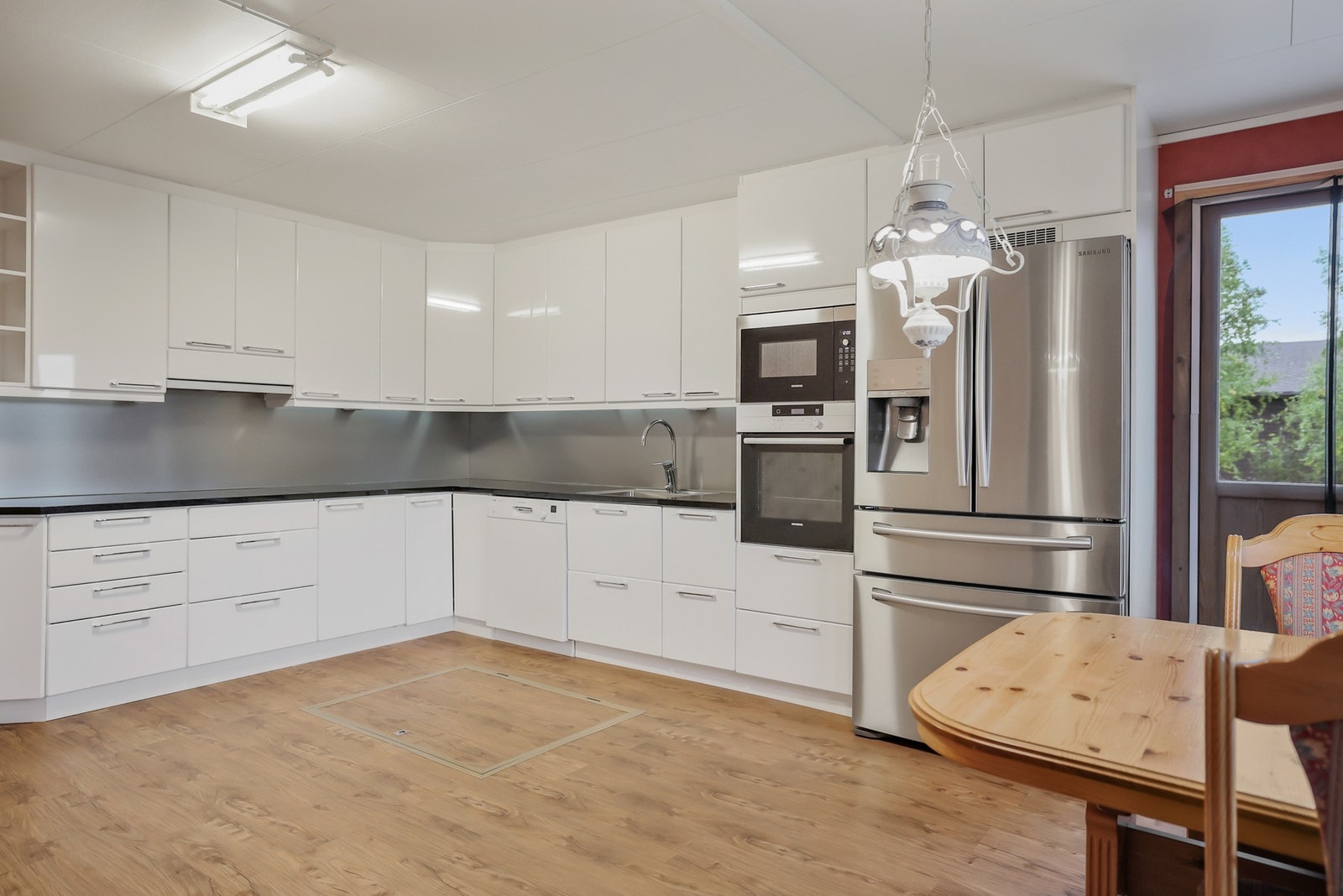 Stort kjøkken som har godt med skap- og benkeplass. Fra kjøkkenet har man utgang til terrasse. Galleribilde