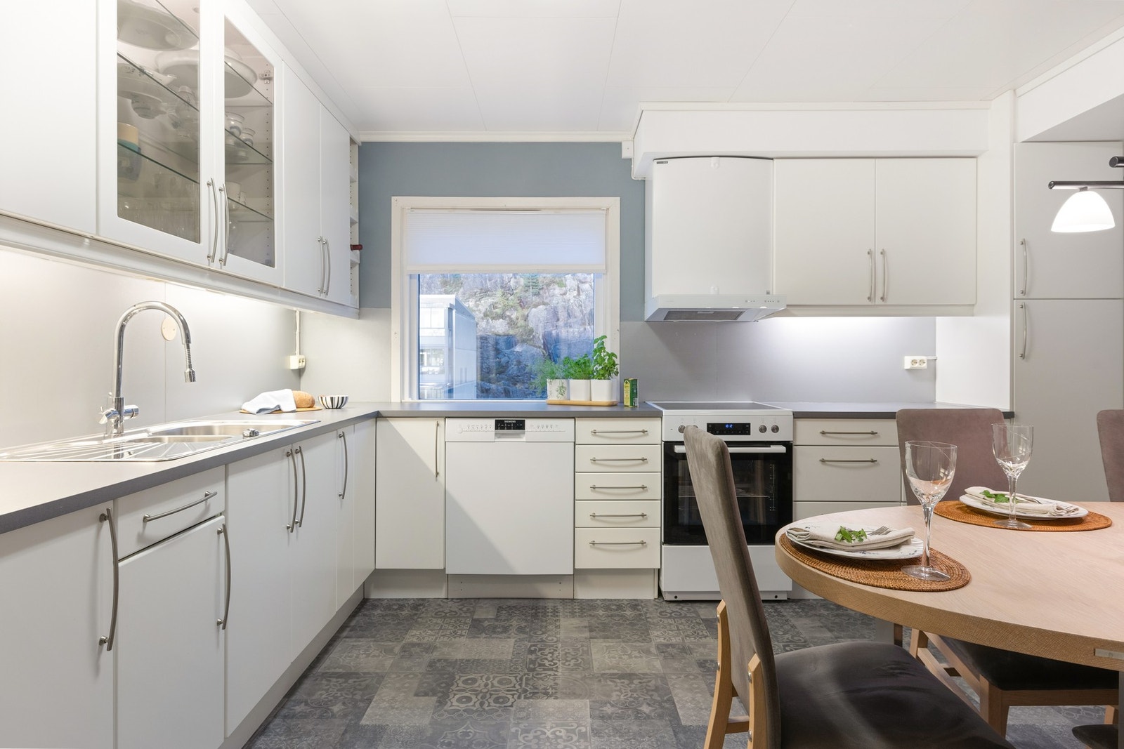 Kjøkkenet har innredning med hvite, slette fronter, laminert benkeplate, ventilator, waterguard og opplegg for oppvaskmaskin Galleribilde