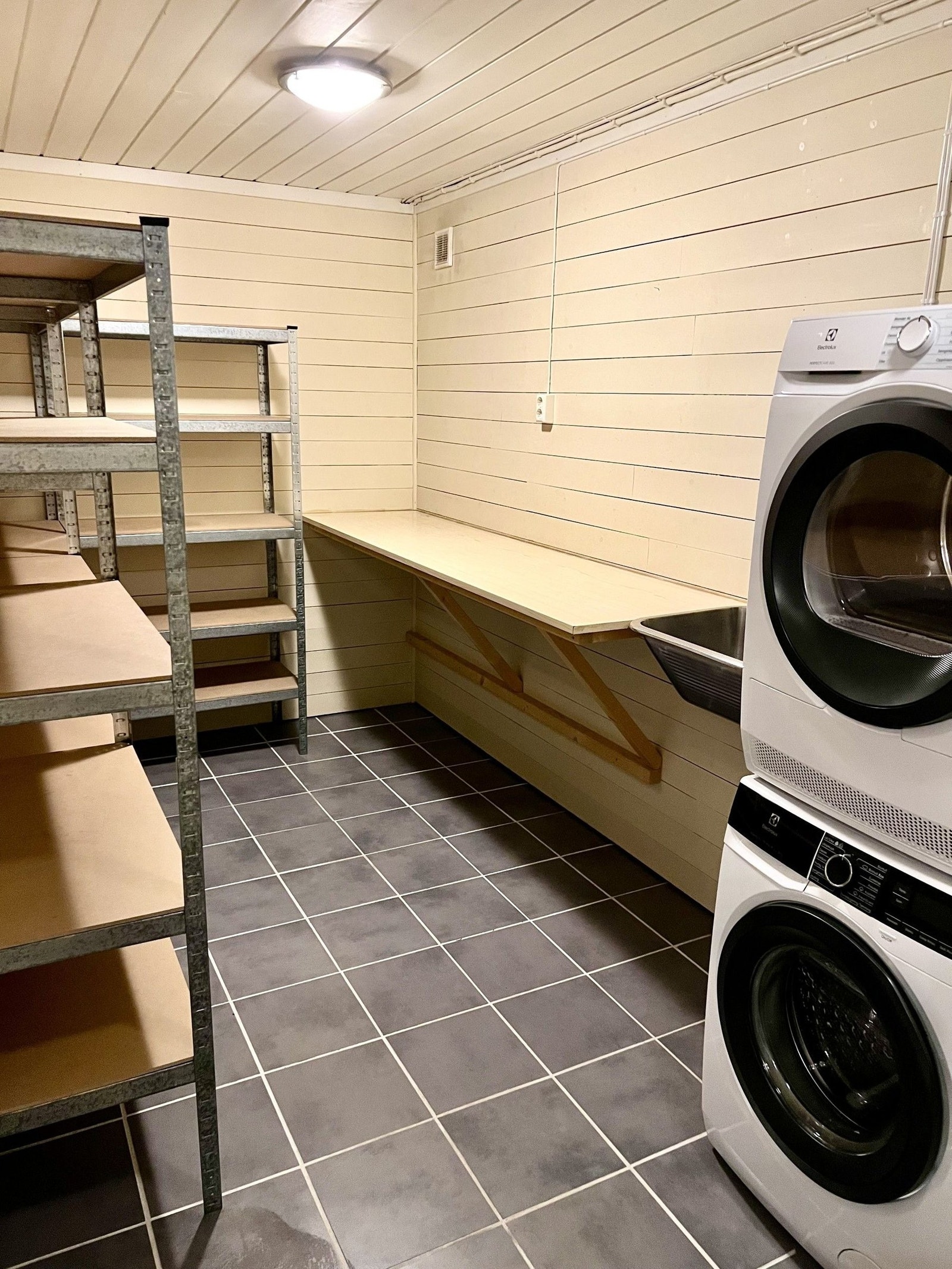 Vaskreom med stor benk og god hyllekapasitet, flislagt gulv. Galleribilde