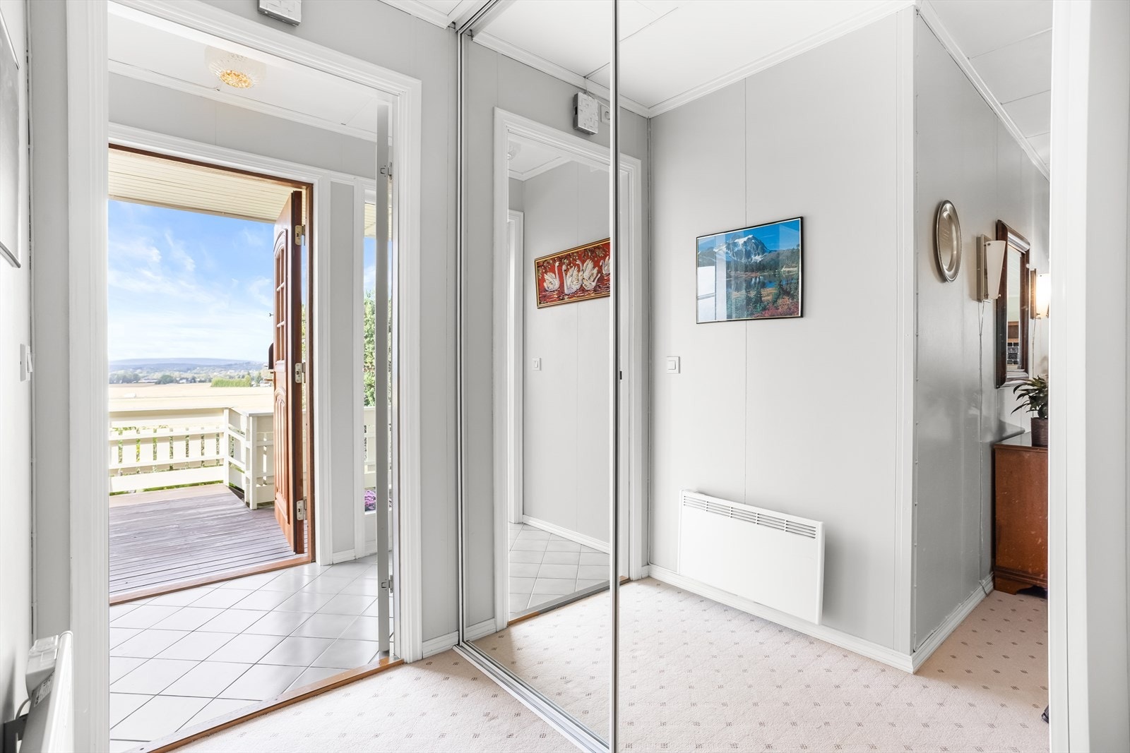 Videre inn i gangen er skyvedørsgarderobe med speilfronter tilgjengelig. Galleribilde