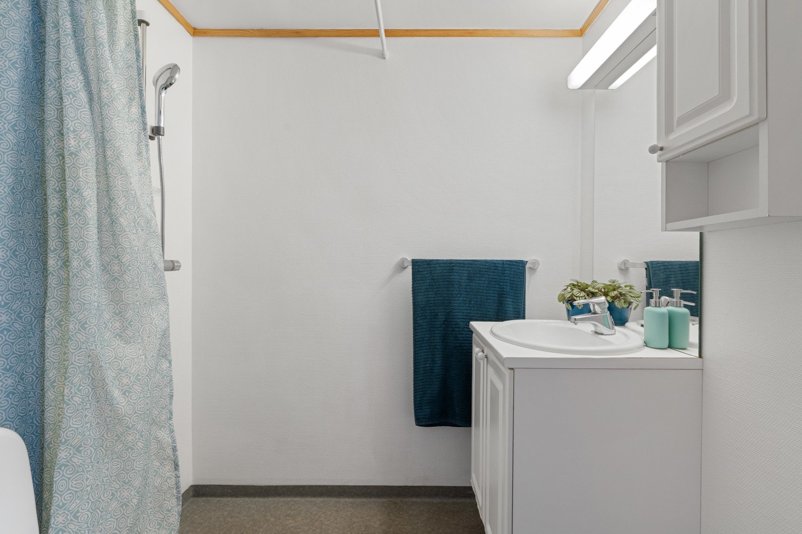 Lyst bad på hybelavdelingen med en hvit innredning med speil. Galleribilde