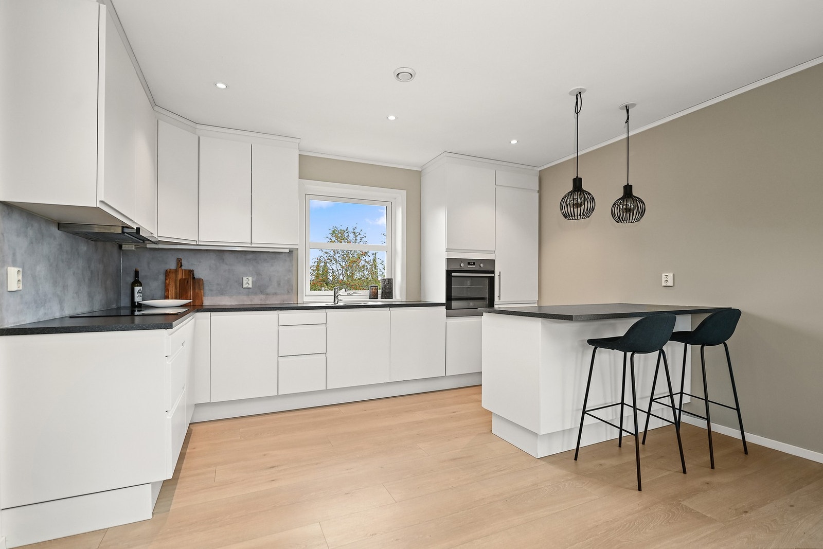 Kjøkkenøy med barløsning lager en fin avgrensning mot stuen. Galleribilde