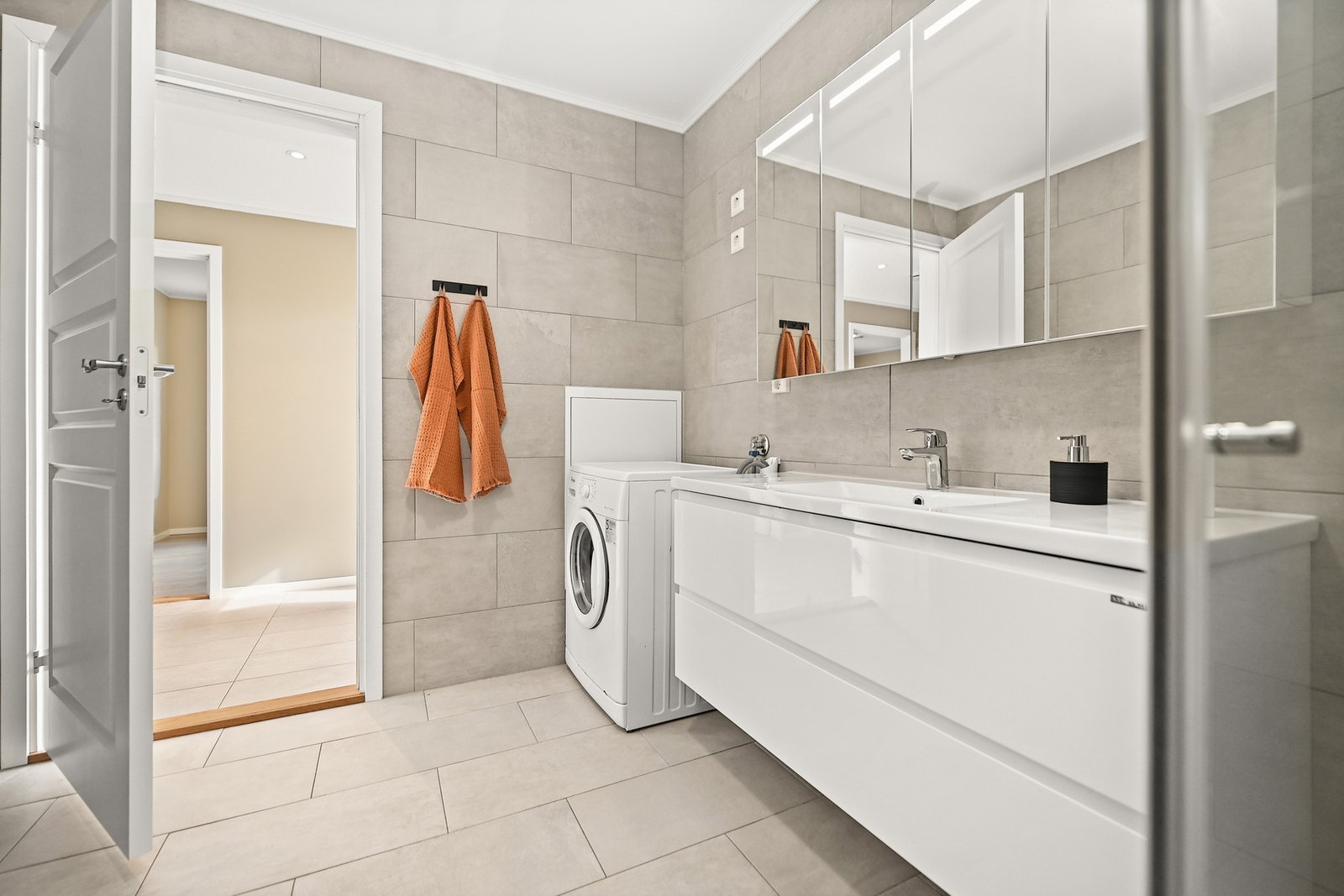 Pen baderomsinnredning og speil med innfelt belysning. Galleribilde