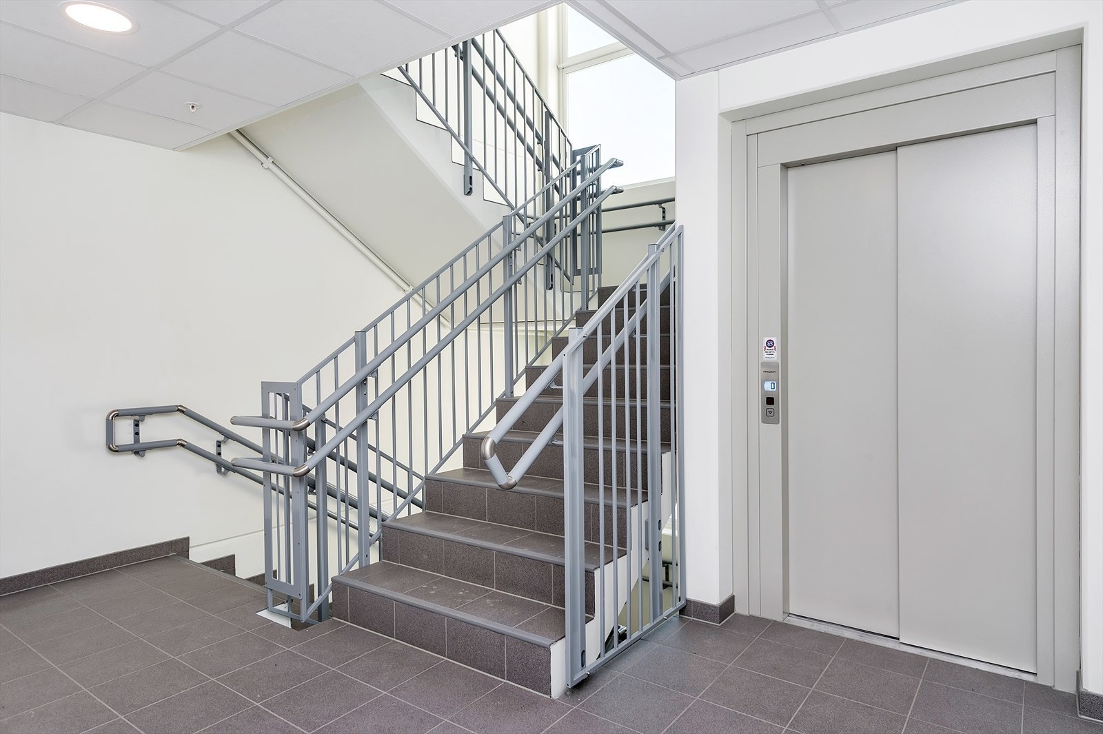 Det er heis og trapp fra parkeringsanlegg i kjeller til 4. etasje. Galleribilde