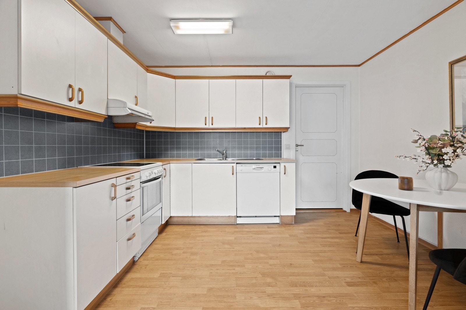 Kjøkkenet er praktisk med frittstående hvitevarer, rikelig skap- og benkeplass, samt plass til spisebord.