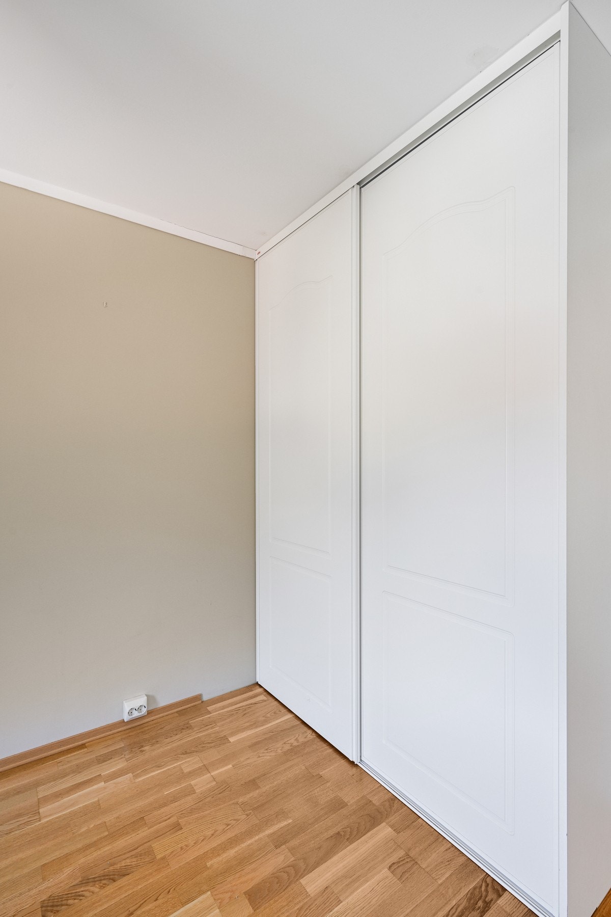 Dette soverommet er et lyst rom med parkettgulv og skyvedørsgarderobe. Galleribilde