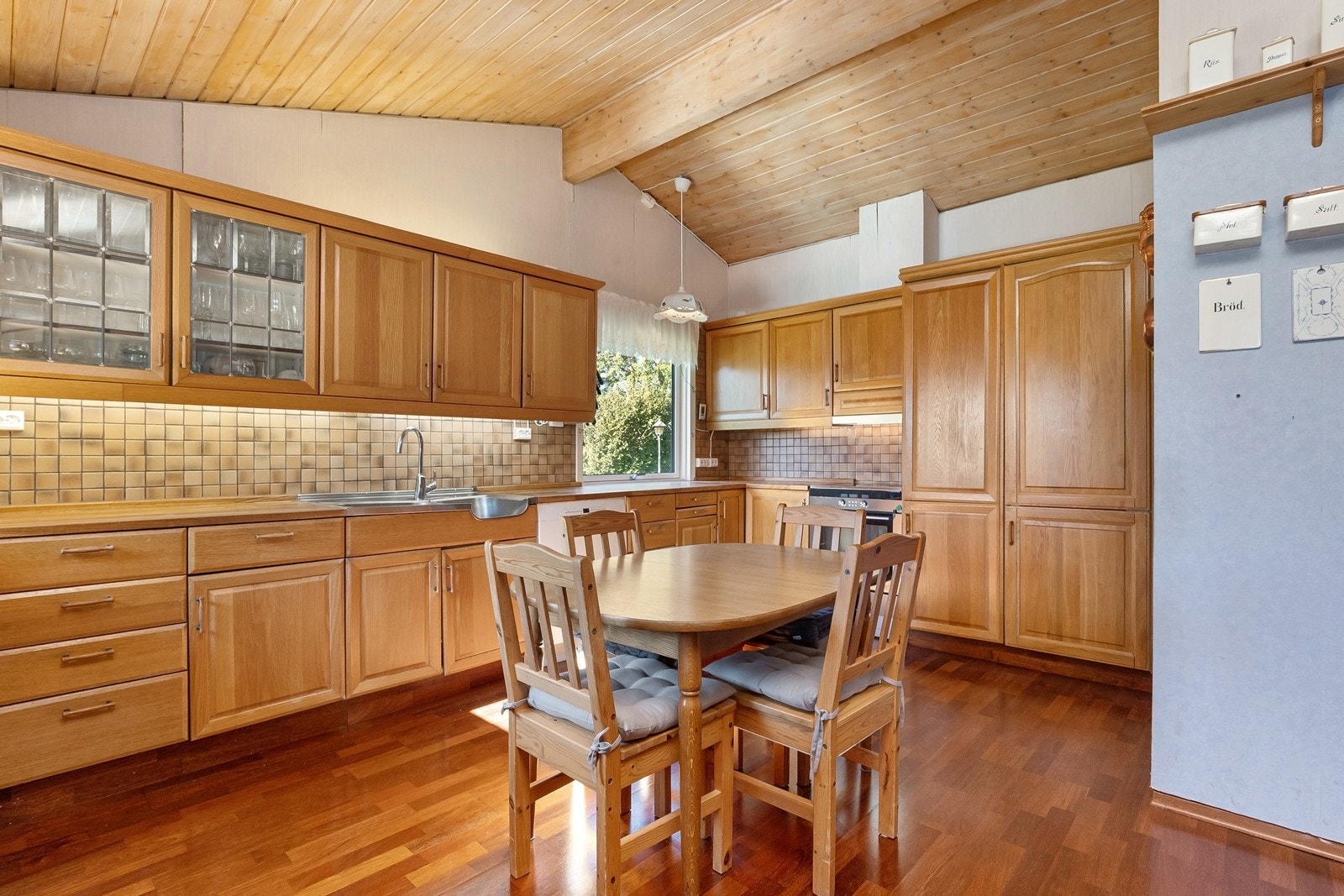 Romslig kjøkken med heltre innredning og godt med plass til spisebord. Galleribilde