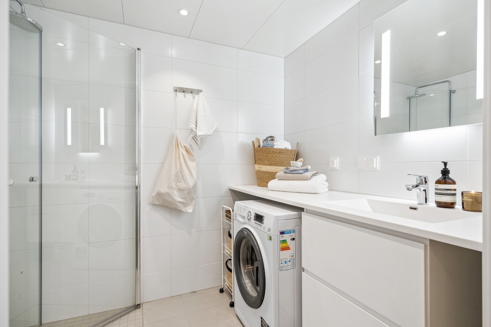 Pent flislagt baderom med moderne innredning og innfellbare dusjdører i glass. Galleribilde