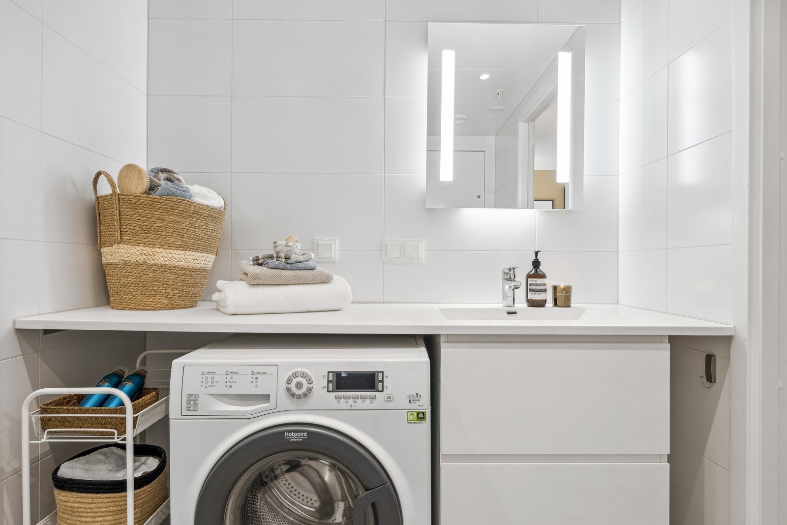 Badet er utstyrt med vegghengt toalett, servantinnredning og dusjhjørne med glassdører, samt opplegg for vaskemaskin. Galleribilde