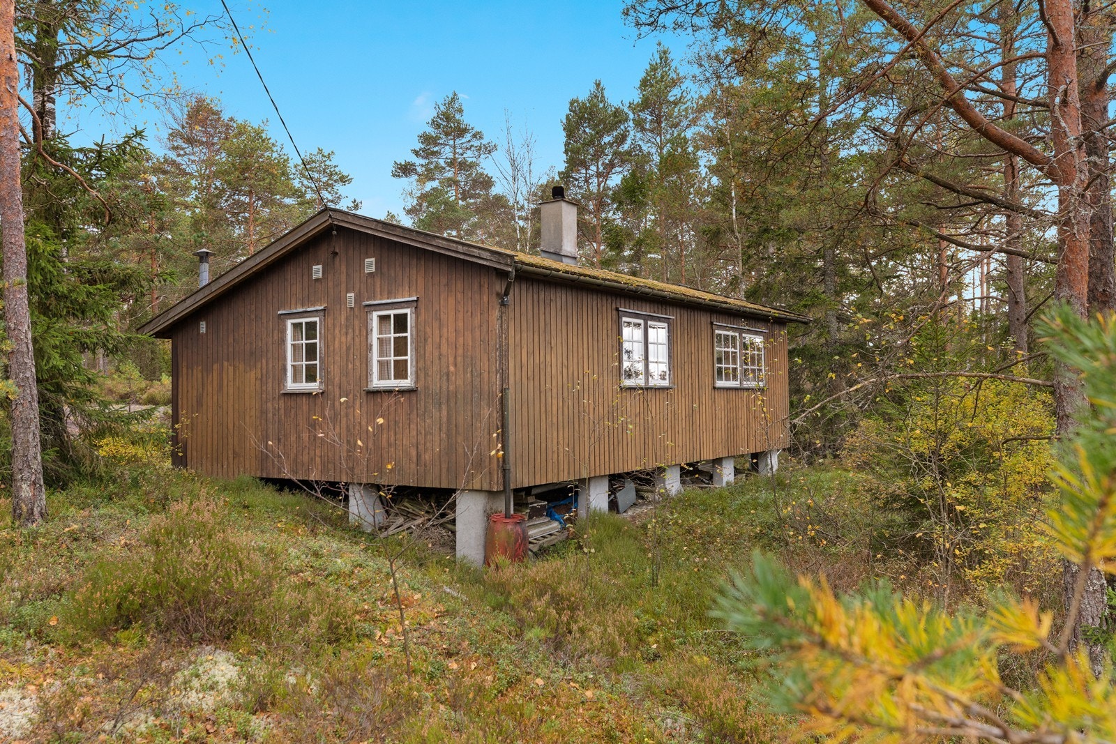 Hytta står oppført på pilarer og ligger relativt usjenert til i forhold til de andre hyttene på feltet Galleribilde