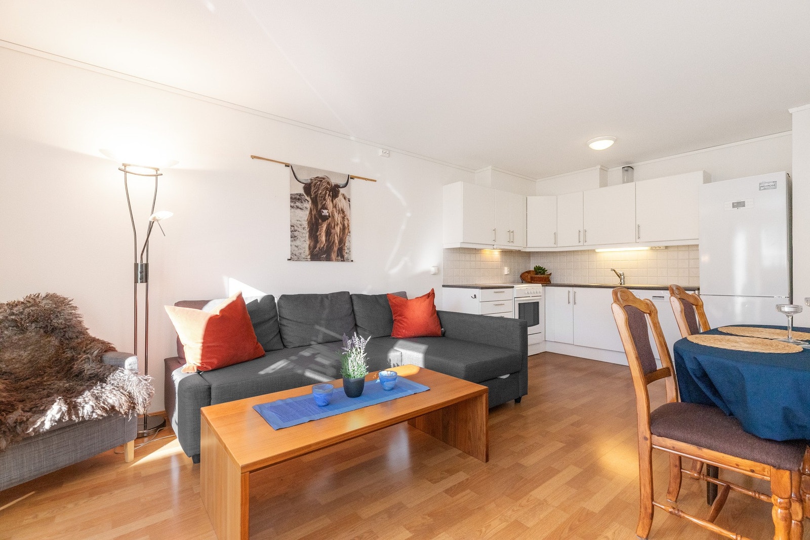 Stue og kjøkken i åpen løsning med flere soner for møblering. Galleribilde