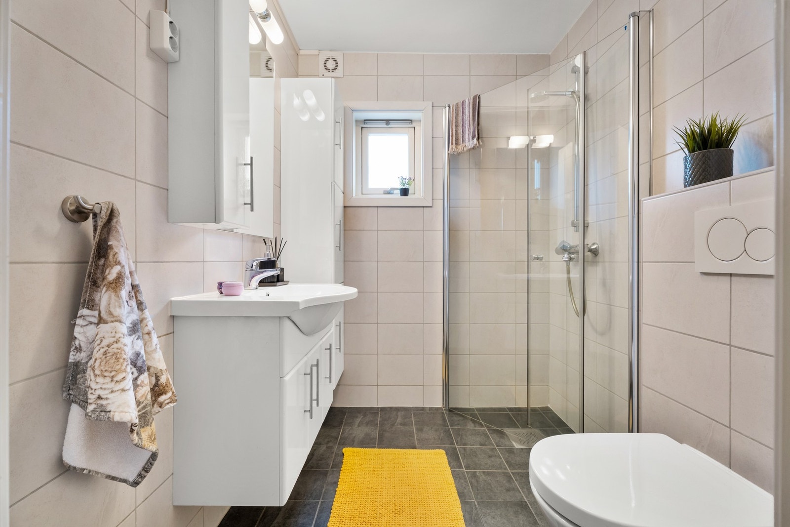 Badet ble pusset opp rundt 2015, innredet med beige veggfliser og mørke gulvfliser. Galleribilde
