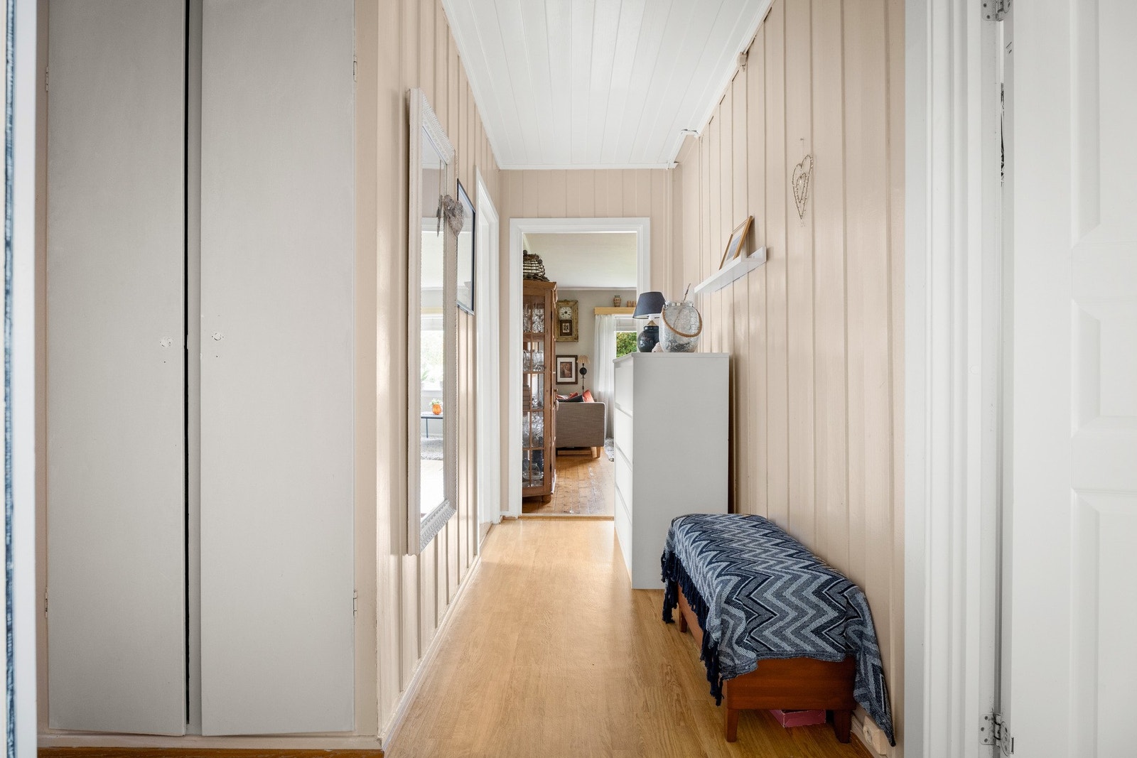 Entreen gulvbelegg, beige panelvegger og et plassbygd garderobeskap med hvite fronter Galleribilde