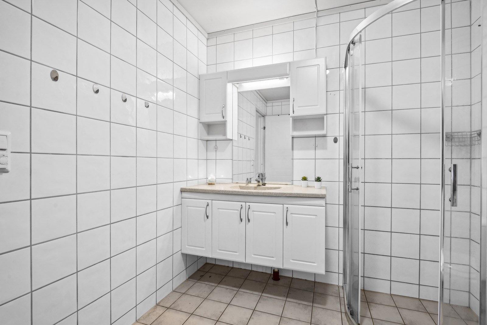 Rommet er utstyrt med servant med underskap, dusjhjørne, toalett og opplegg for vaskemaskin. Galleribilde