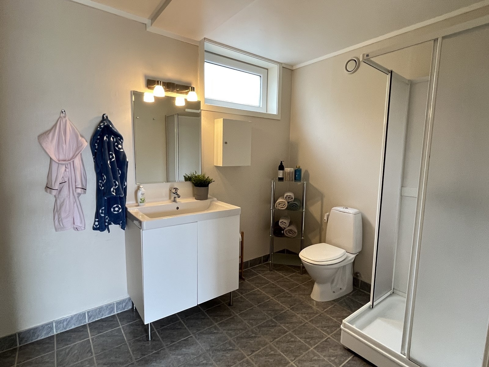 Badet har flislagt gulv med varmekabler, malte plater på veggene og himling med malt gips. Galleribilde