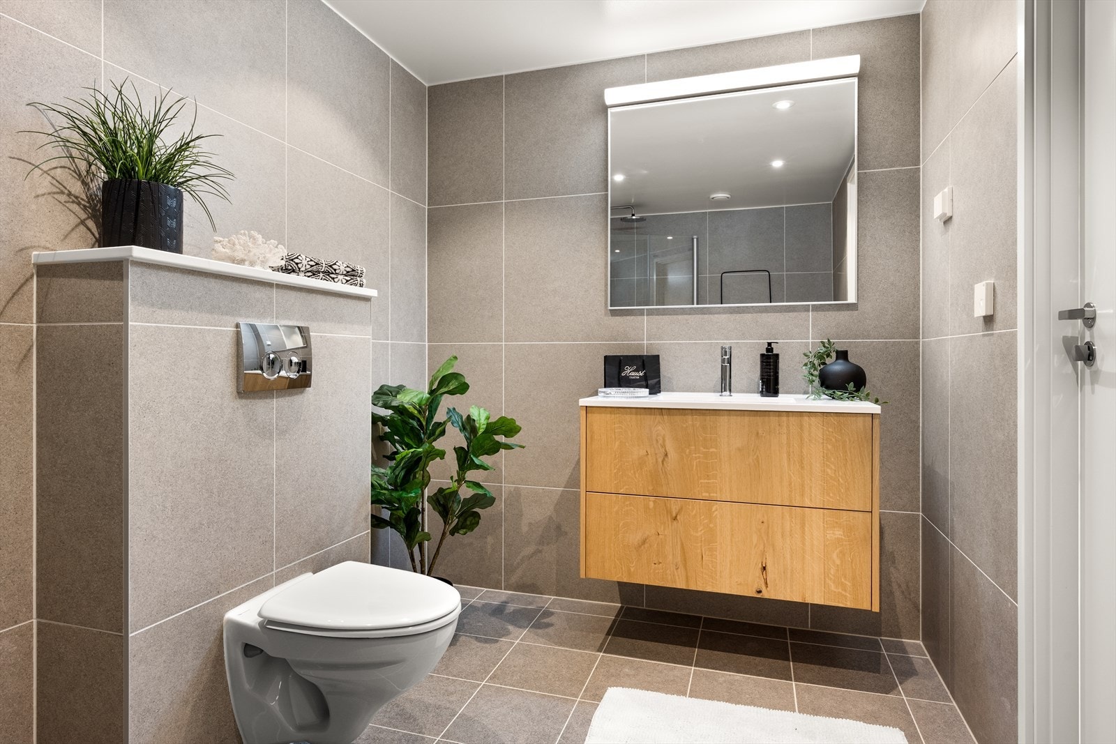 Servant i innredningen, vegghengt toalett og dusjhjørne. Galleribilde