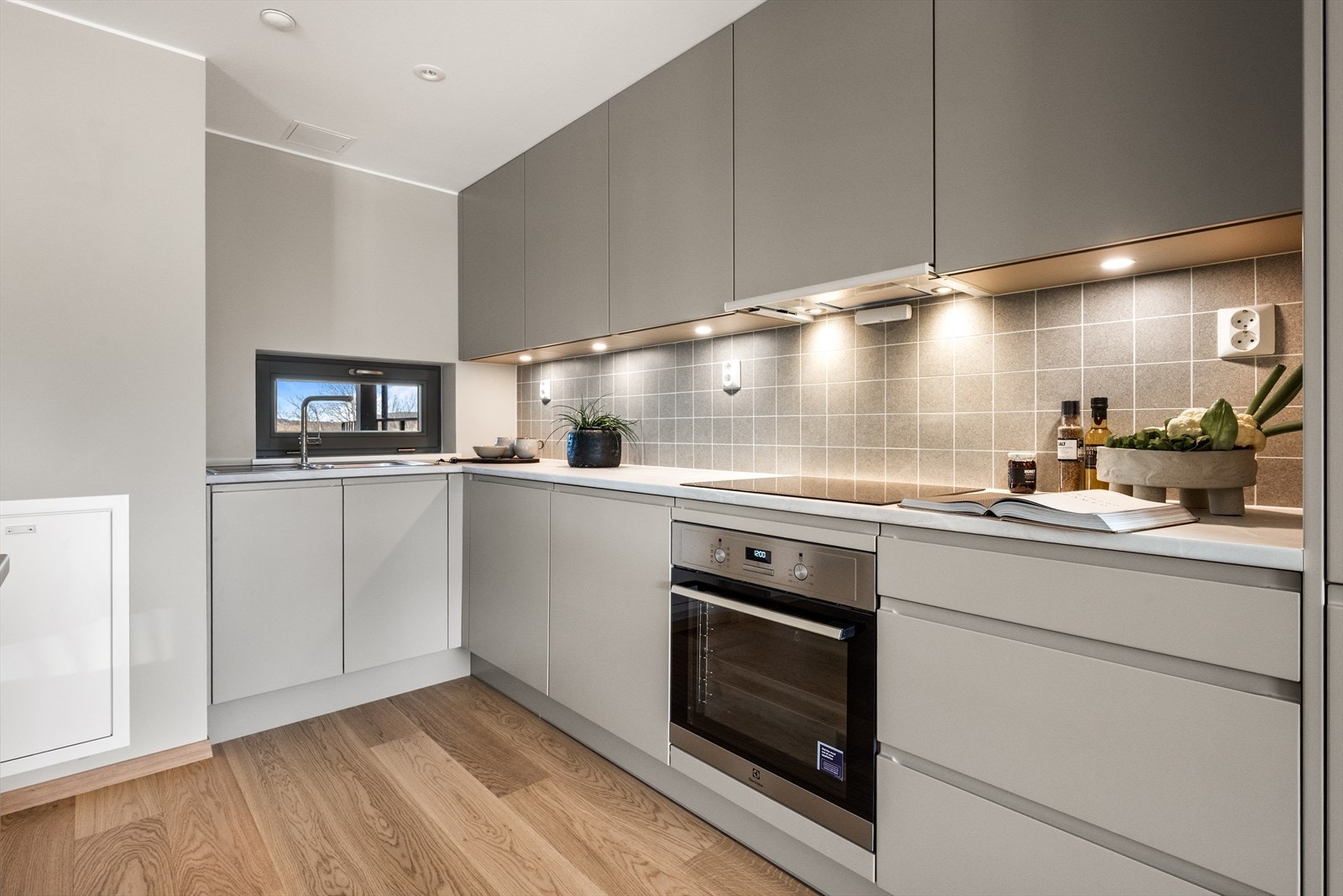 Kjøkkeninnredning i en delikat farge med glatte fronter og slitesterk benkeplate i laminat. Galleribilde