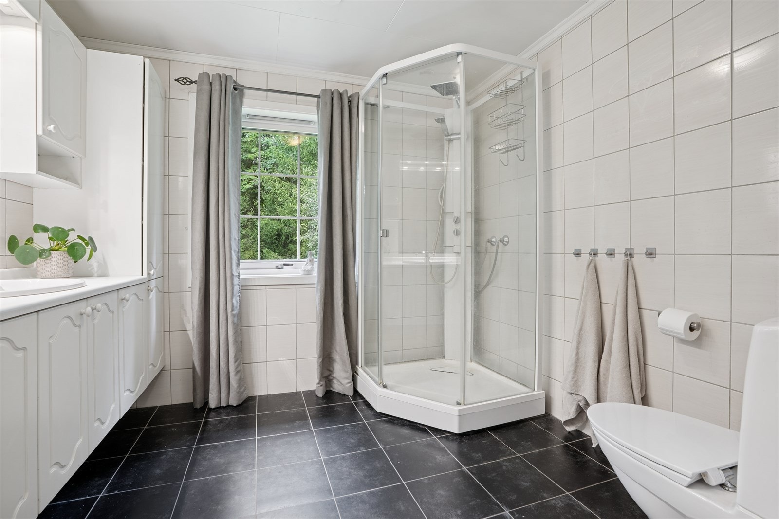 Badet i 1 etg er flislagt med gulvvarme. Badet er fra byggeår men i følge eier er badet modernisert med nyere fliser på gulv. Det er lagt flis på flis. Galleribilde