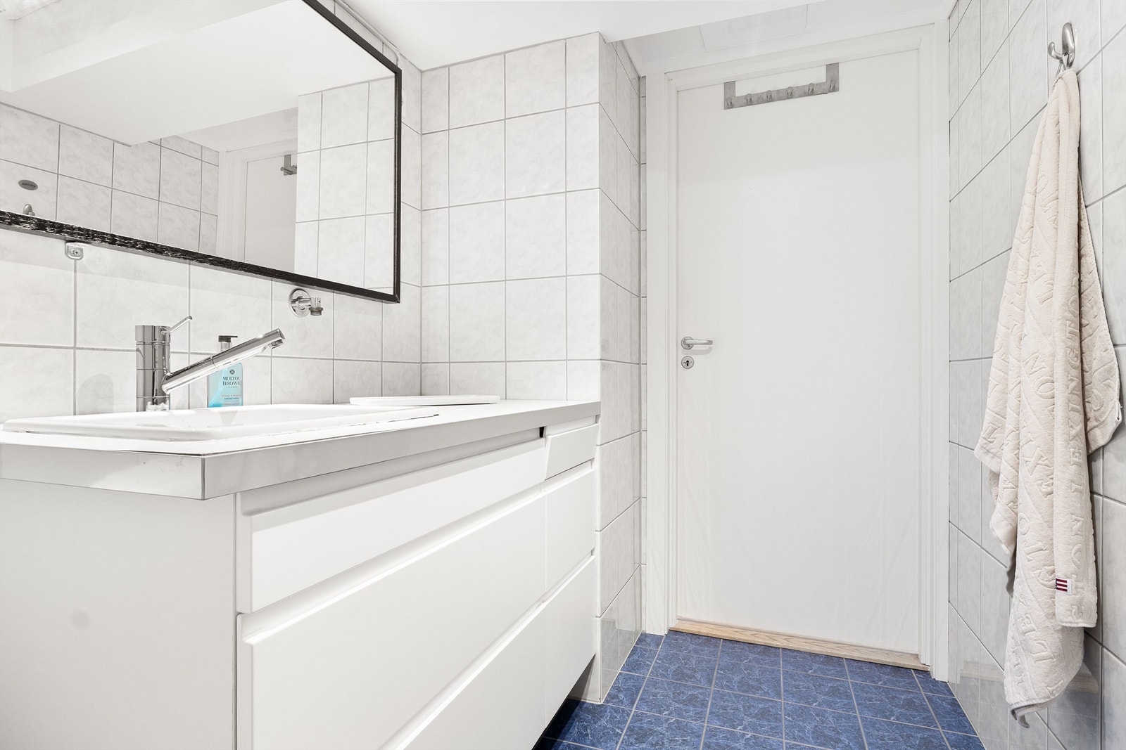 Lyst og romslig helfliset bad med opplegg for vaskemaskin. Galleribilde