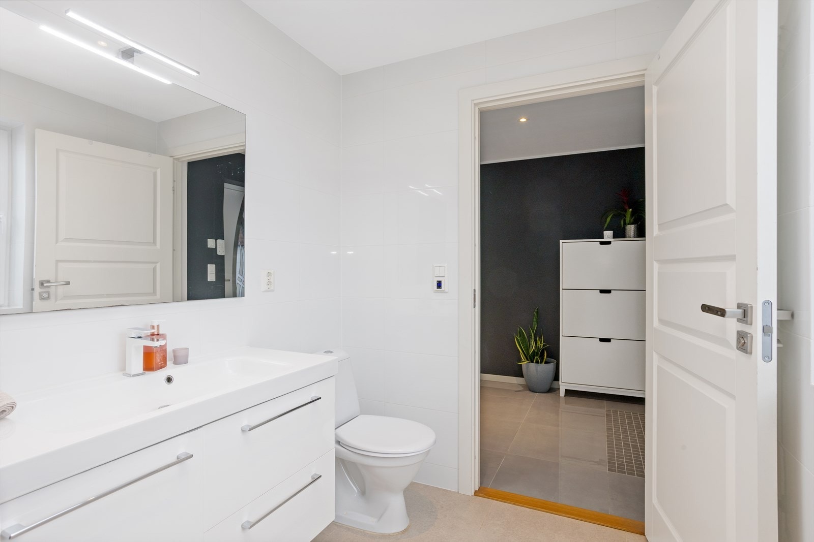 Veggmontert toalett og moderne servantinnredning med oppbevaringsplass. Galleribilde