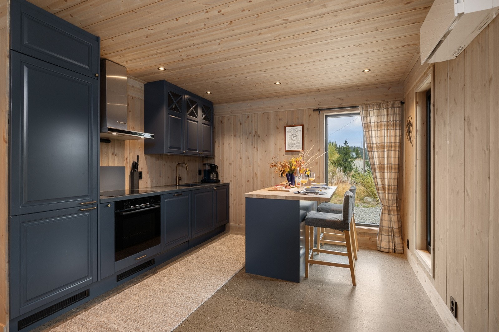 Kjøkkenet har innredning med profilerte fronter og benkeplate av eksklusiv stein og tre . Galleribilde