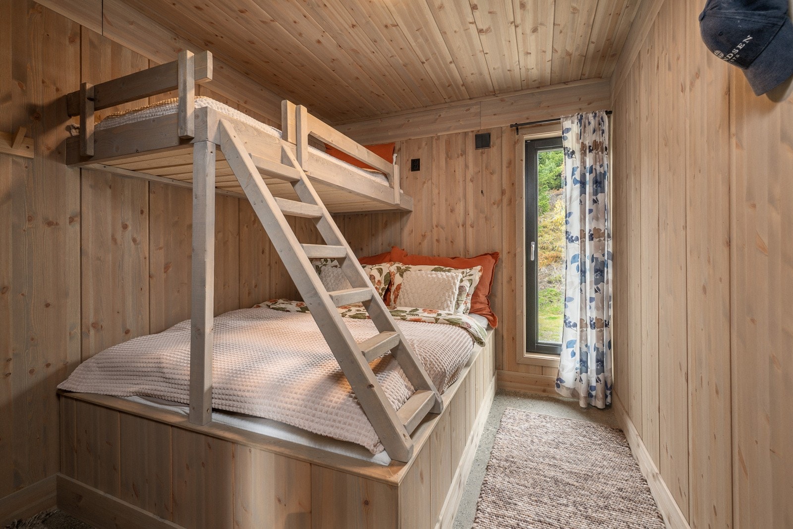 Plassbygget køyeseng med samme panel som det er på veggene. Galleribilde