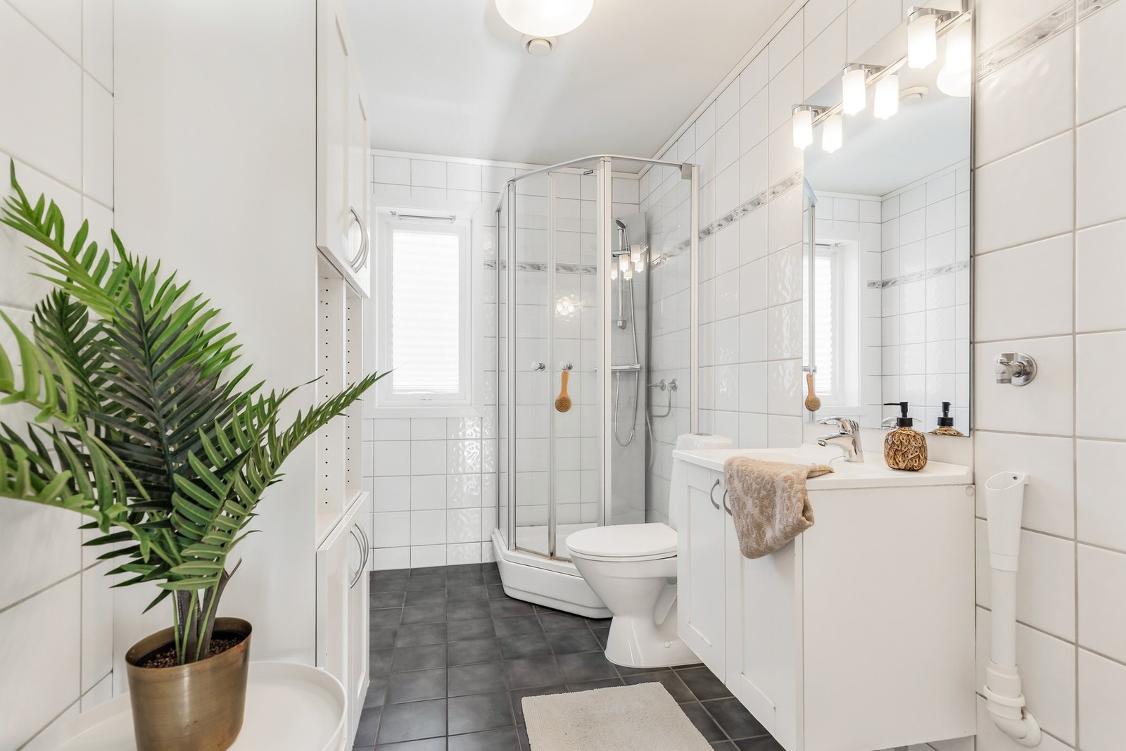 Badet har pene, tidløse fliser. Dusjkabinett og pent interiør Galleribilde