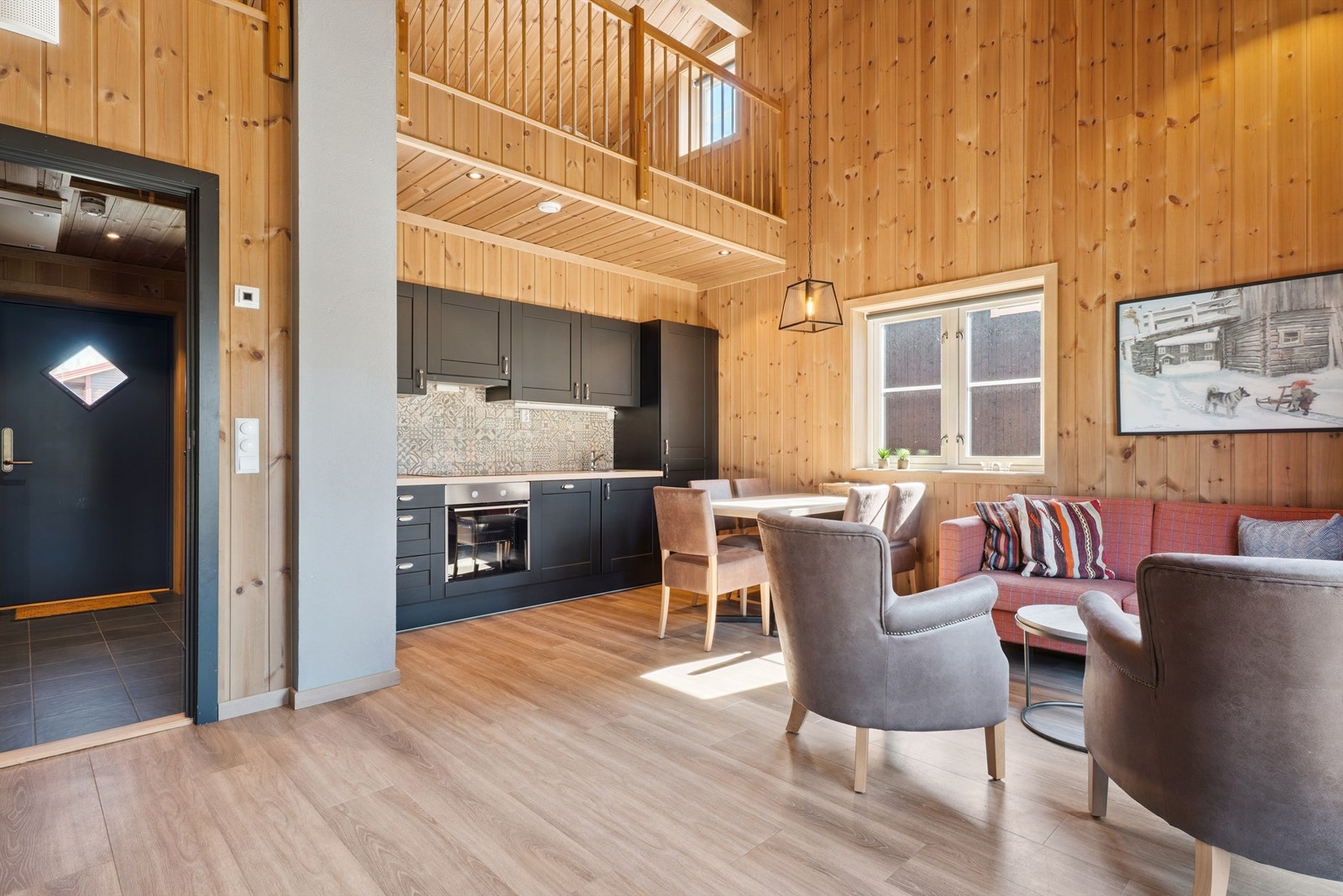 Stuen og kjøkkenet utgjør et lyst og sosialt allrom med god takhøyde og panel på vegger. Galleribilde