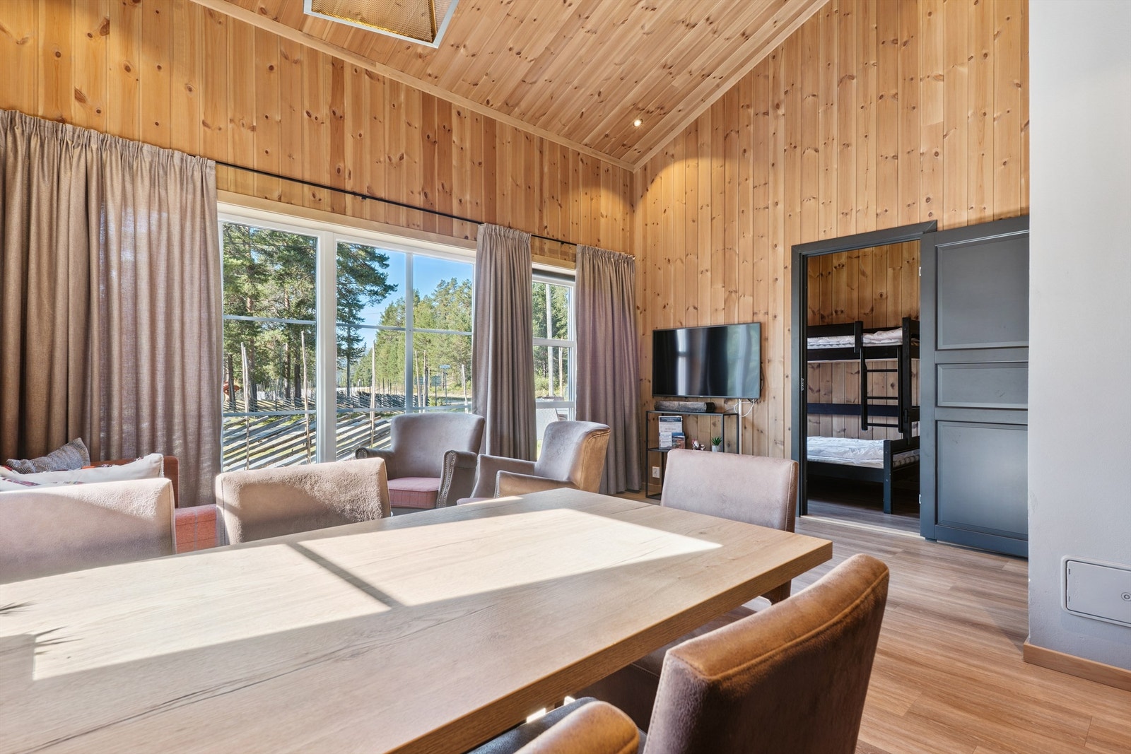 Fra stuen er det utsikt mot uteområdet og adkomst til et av soverommene. Galleribilde