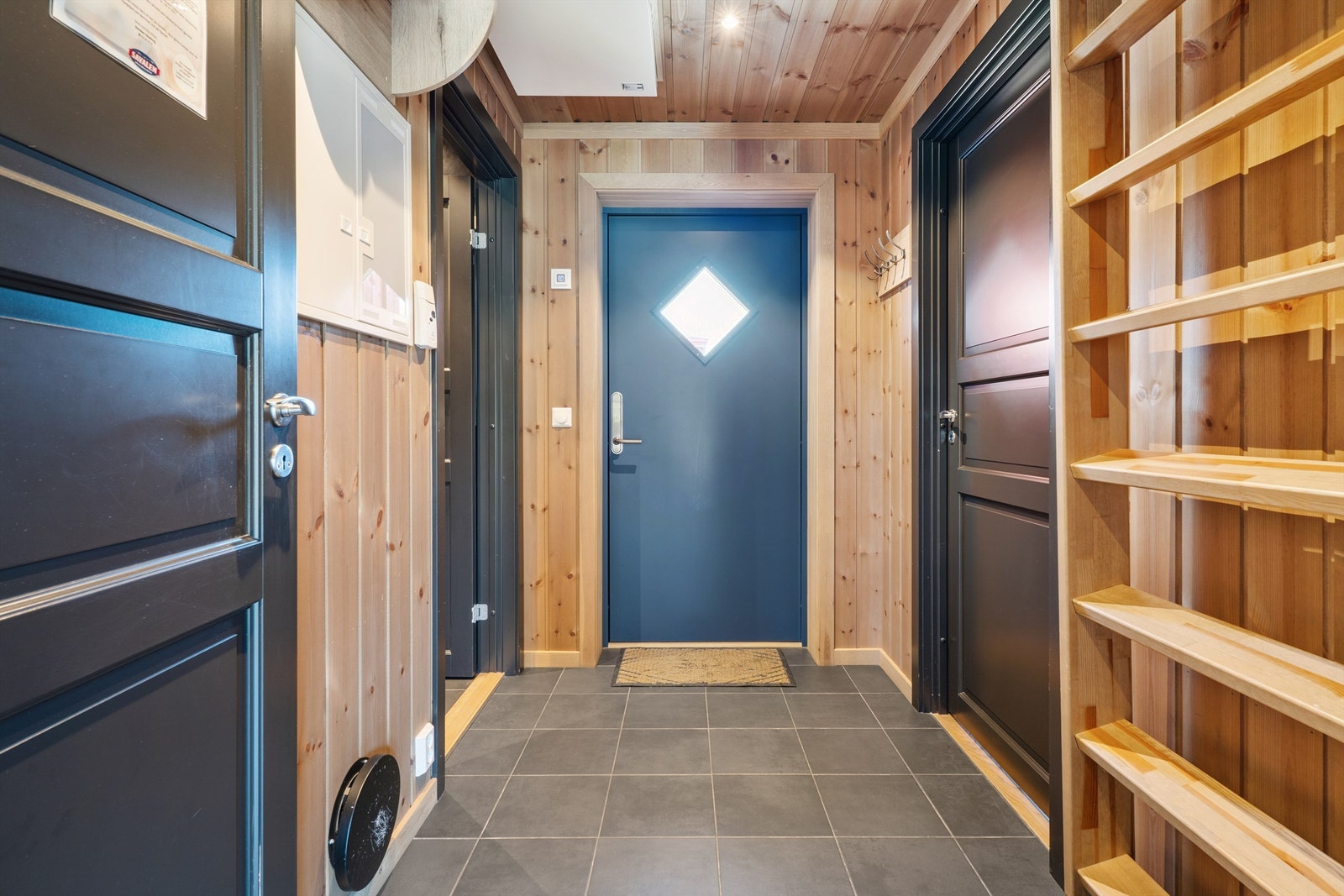 Velkommen inn i en praktisk entré med flislagt gulv og gulvvarme for god komfort. Galleribilde