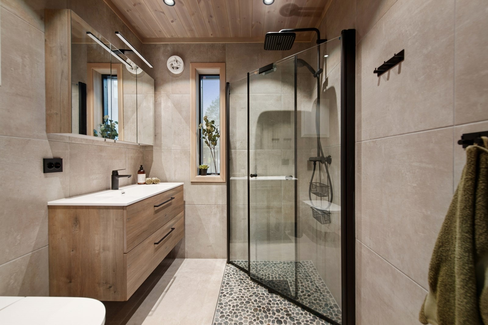 Hytta har to delikate og lekre bad - begge flislagte og innredet med stil og komfort. Badet i første etasje har flislagte overflater, rikelig med oppbevaring, dusjhjørne, veggmontert toalett, speilskap med lys og heldekkende servant - praktisk og stilrent Galleribilde