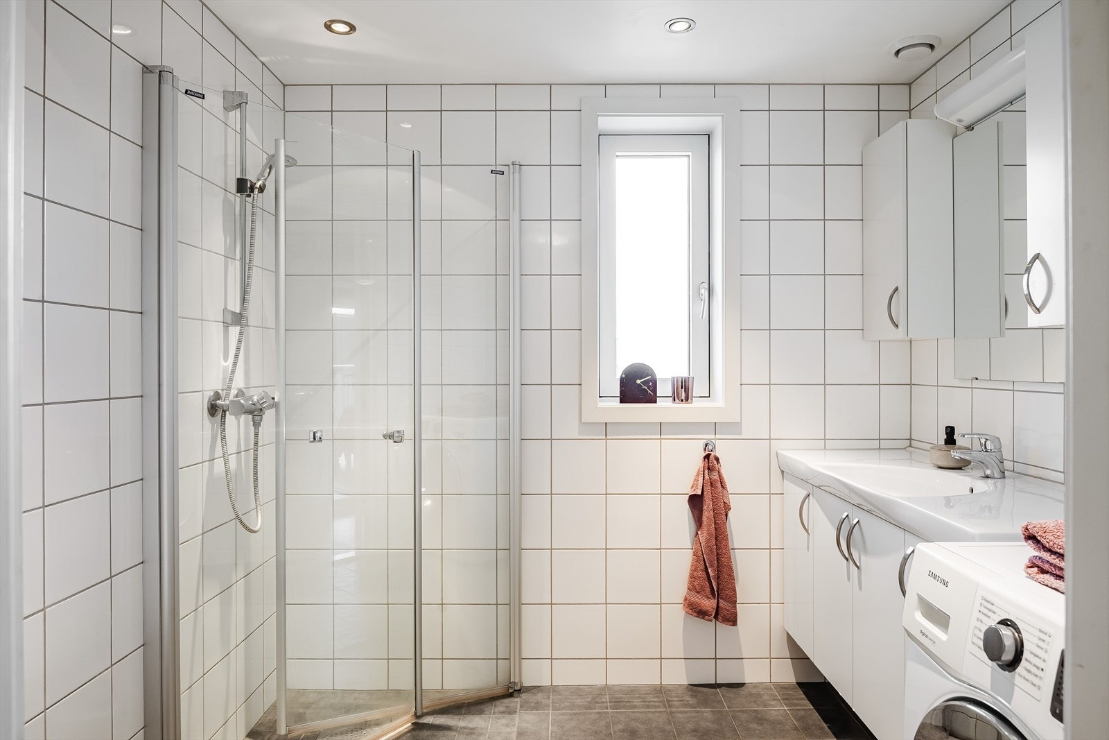 Pent baderom fra byggeåret med fliser på gulv og vegger. Vannbåren gulvvarme og downlights i himlingen. Galleribilde