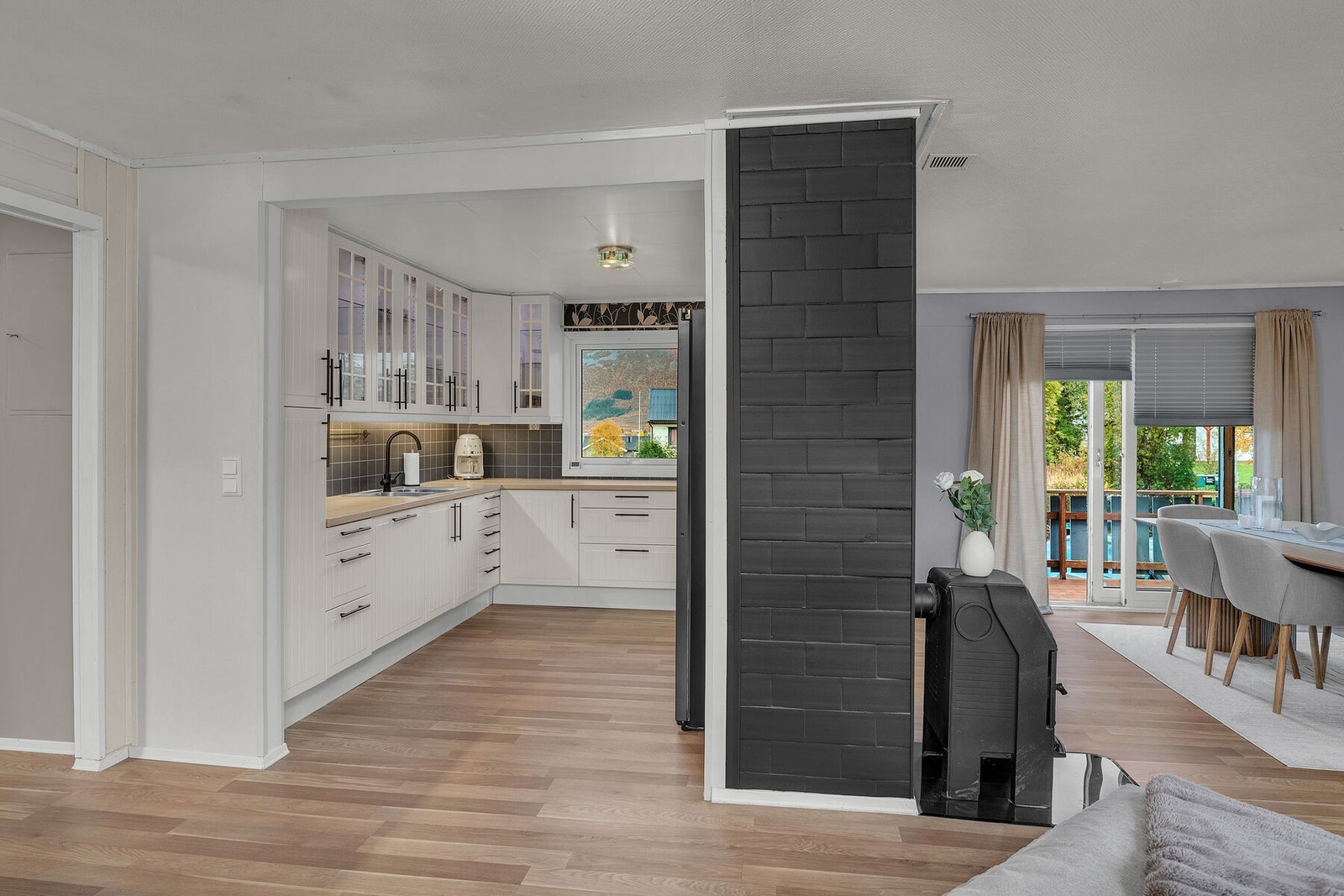 Stue og kjøkken i åpen løsning. Store vindusflater gir rikelig med dagslys og fin utsikt mot nærområdet. Galleribilde