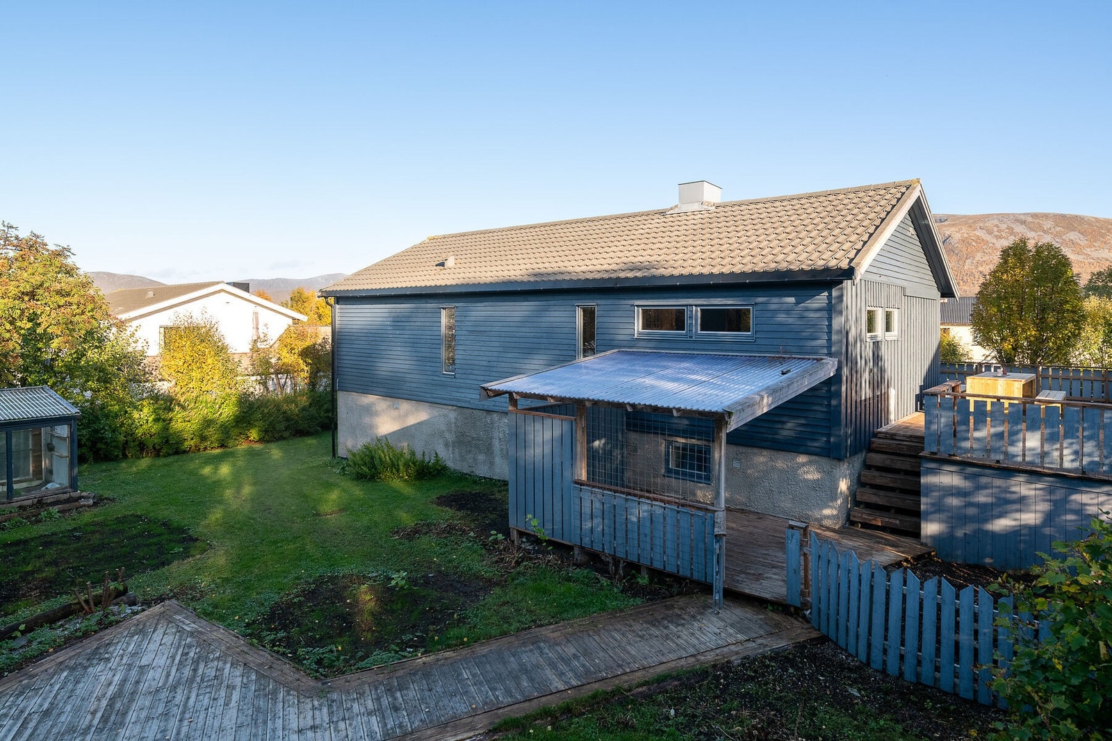 Fasade og uteområde. Den store hagen gir barna trygge omgivelser for lek, samtidig som den innbyr til hyggelige stunder for hele familien. Det er parkering på tomten. Galleribilde