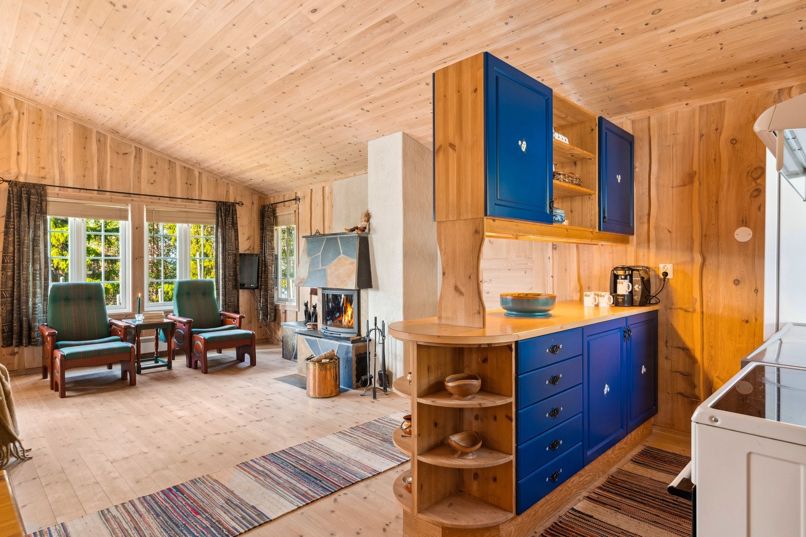 Kjøkkenet har en praktisk halvøy som gir ekstra skap - og benkeplass, og samtidig sørger for at er enkelt å kombinere matlaging med sosialt samvær. Galleribilde