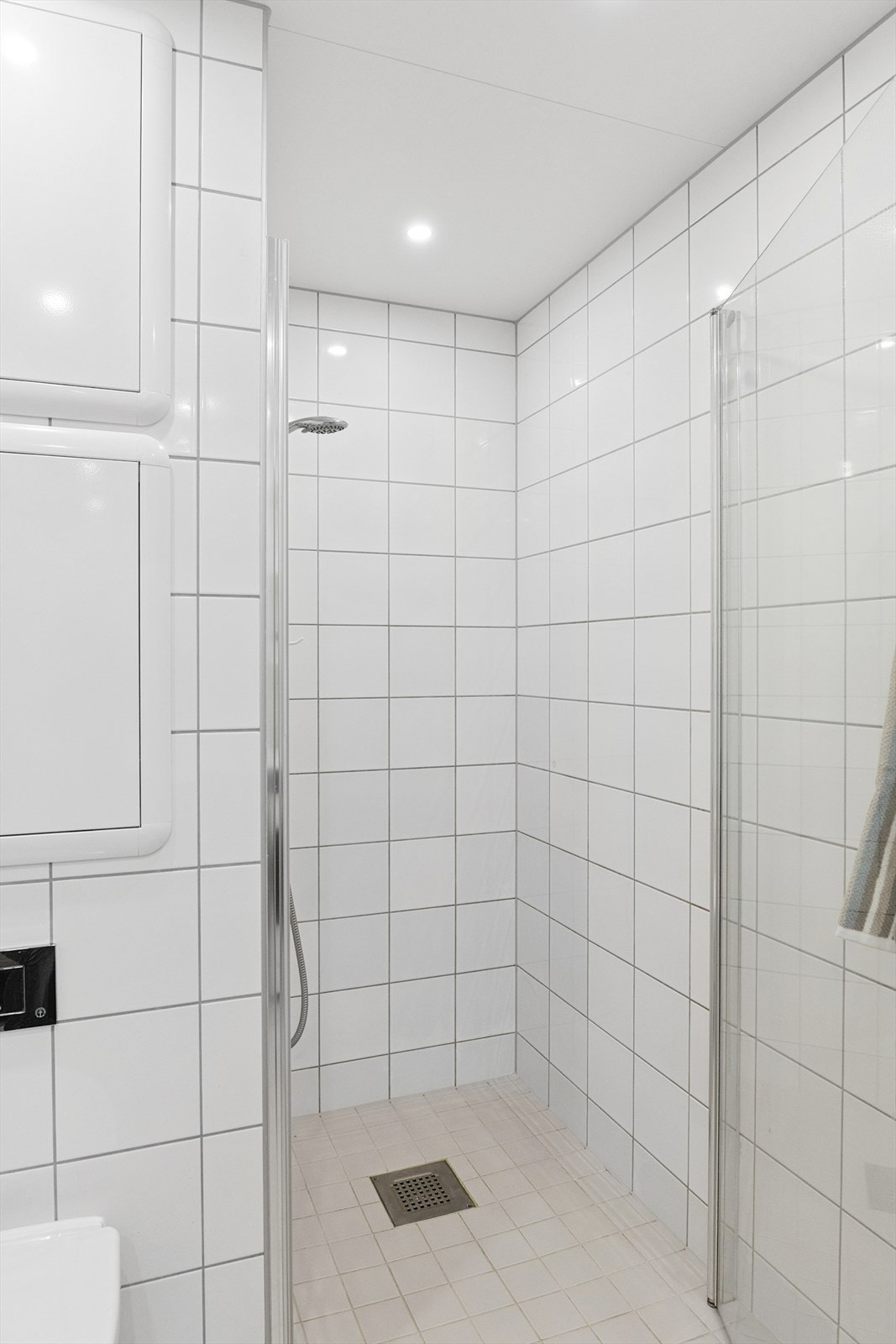 Badet i 2. etasje er innredet med et veggmontert toalett, baderomsinnredning med heldekkende servant, speil og dusjnisje. Galleribilde