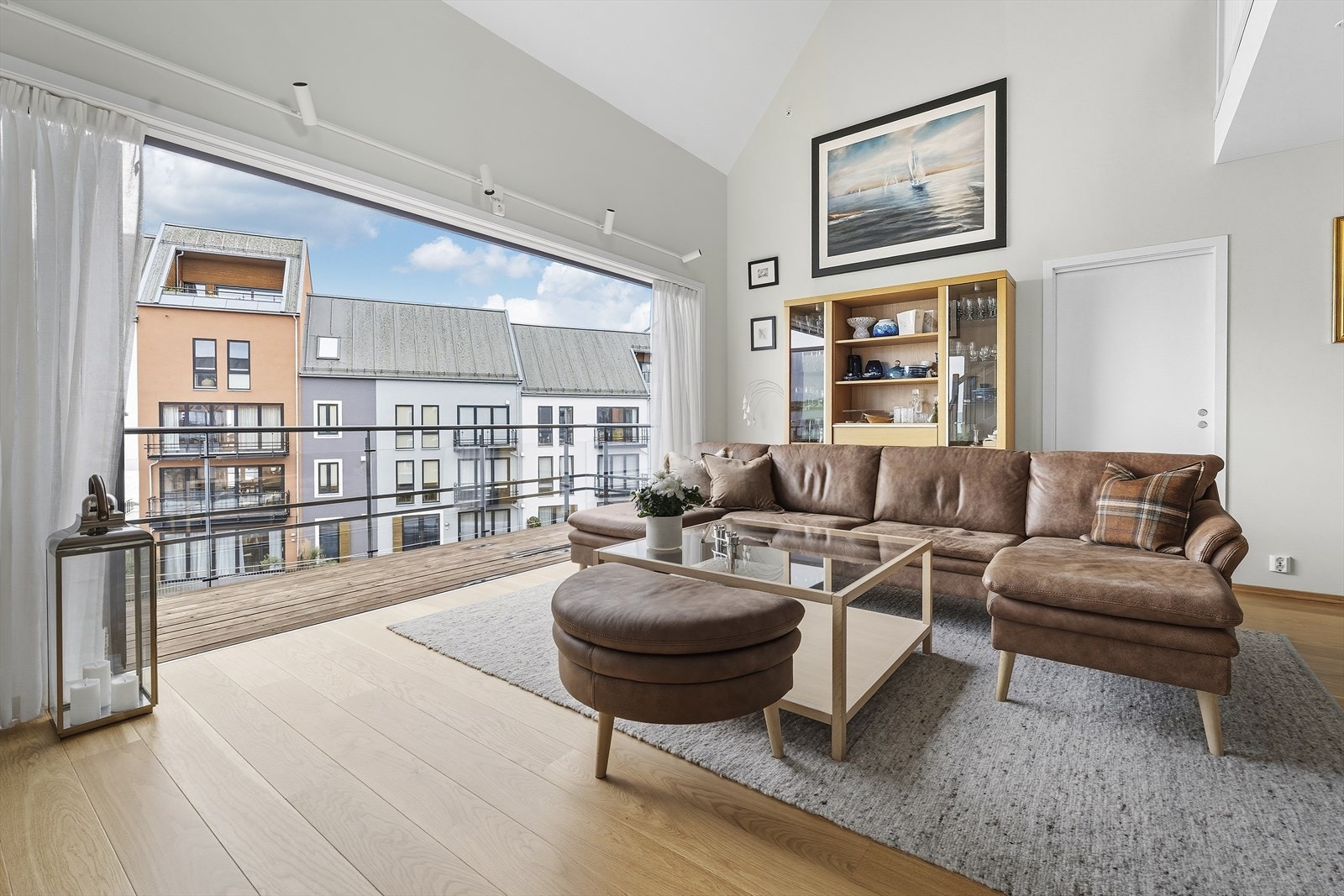 Stuen har terrassedører som kan åpnes helt opp ut mot balkong slik at skillet mellom inne og ute viskes ut Galleribilde