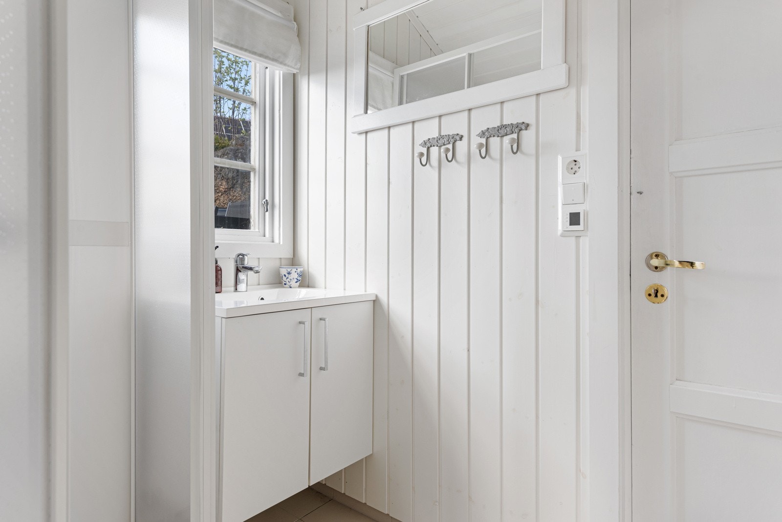 Av innredning er det en hvit skapseksjon med heldekkende servant. To vinduer slipper inn godt med lys. Galleribilde