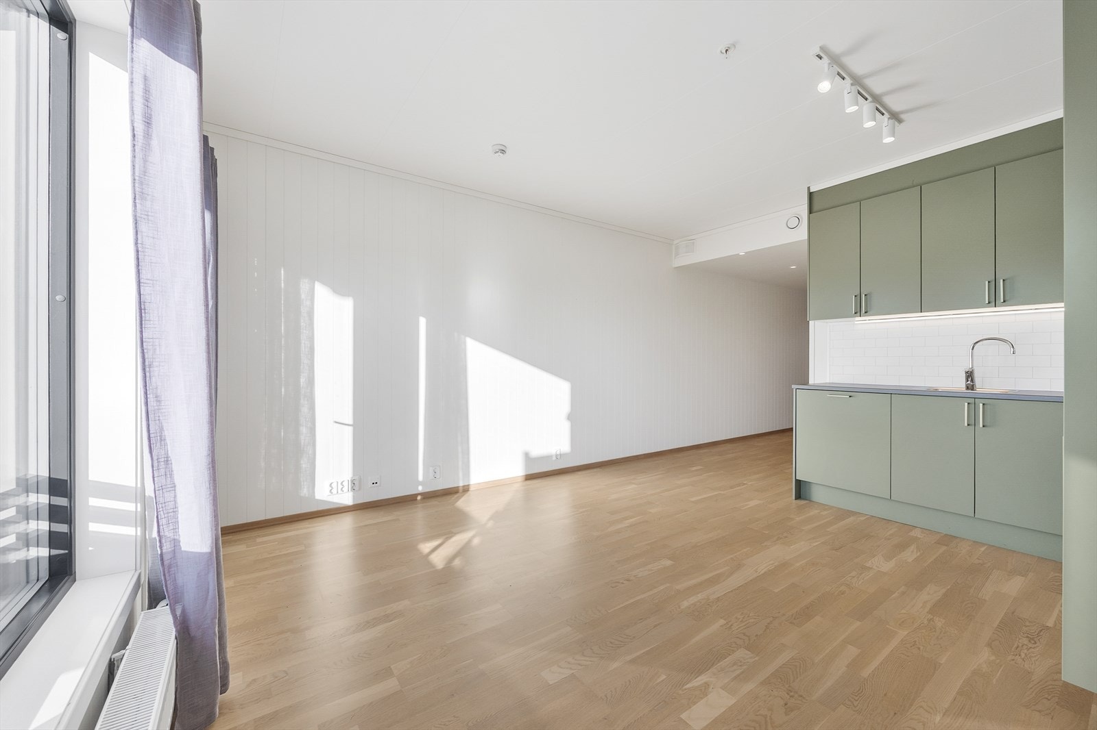 Innredningen er stilren med slette fronter, laminat benkeplate og belysning under overskap. Galleribilde