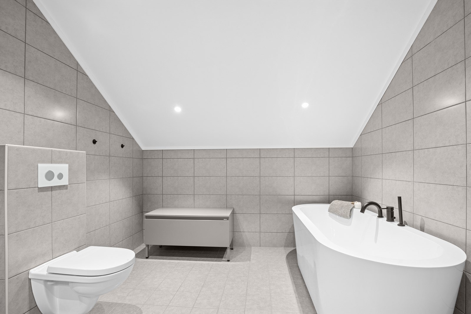 Det er grå fliser på vegg og gulv, som gir et sammenhengende inntrykk Galleribilde