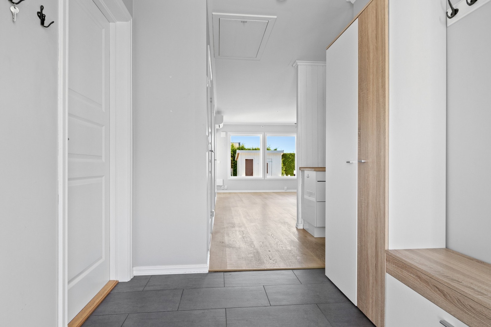 Entreen gråmalte vegger og flislagt gulv med varme. Galleribilde