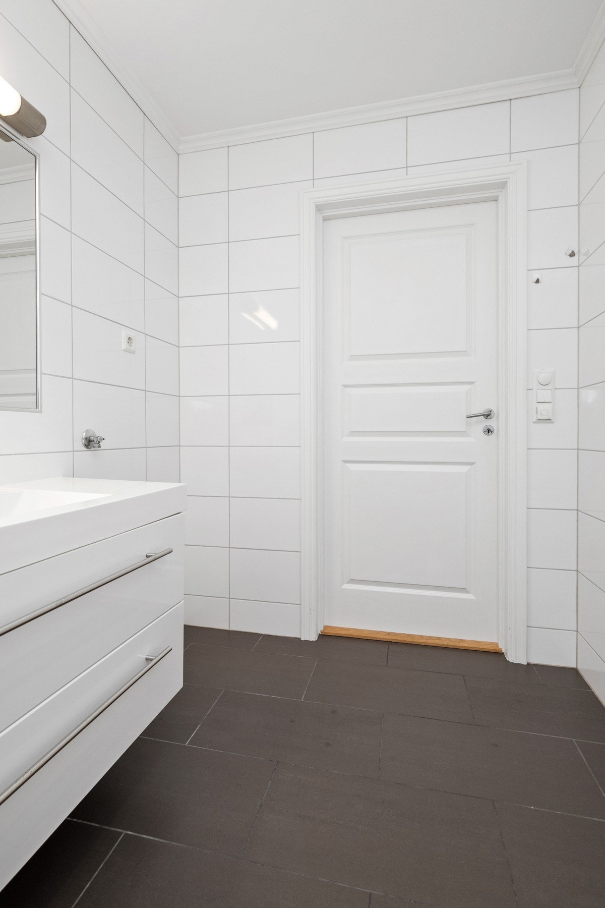 Badet har opplegg for vaskemaskin, varmekabler, vegghengt toalett og et dusjhjørne med innfellbare vegger. Galleribilde