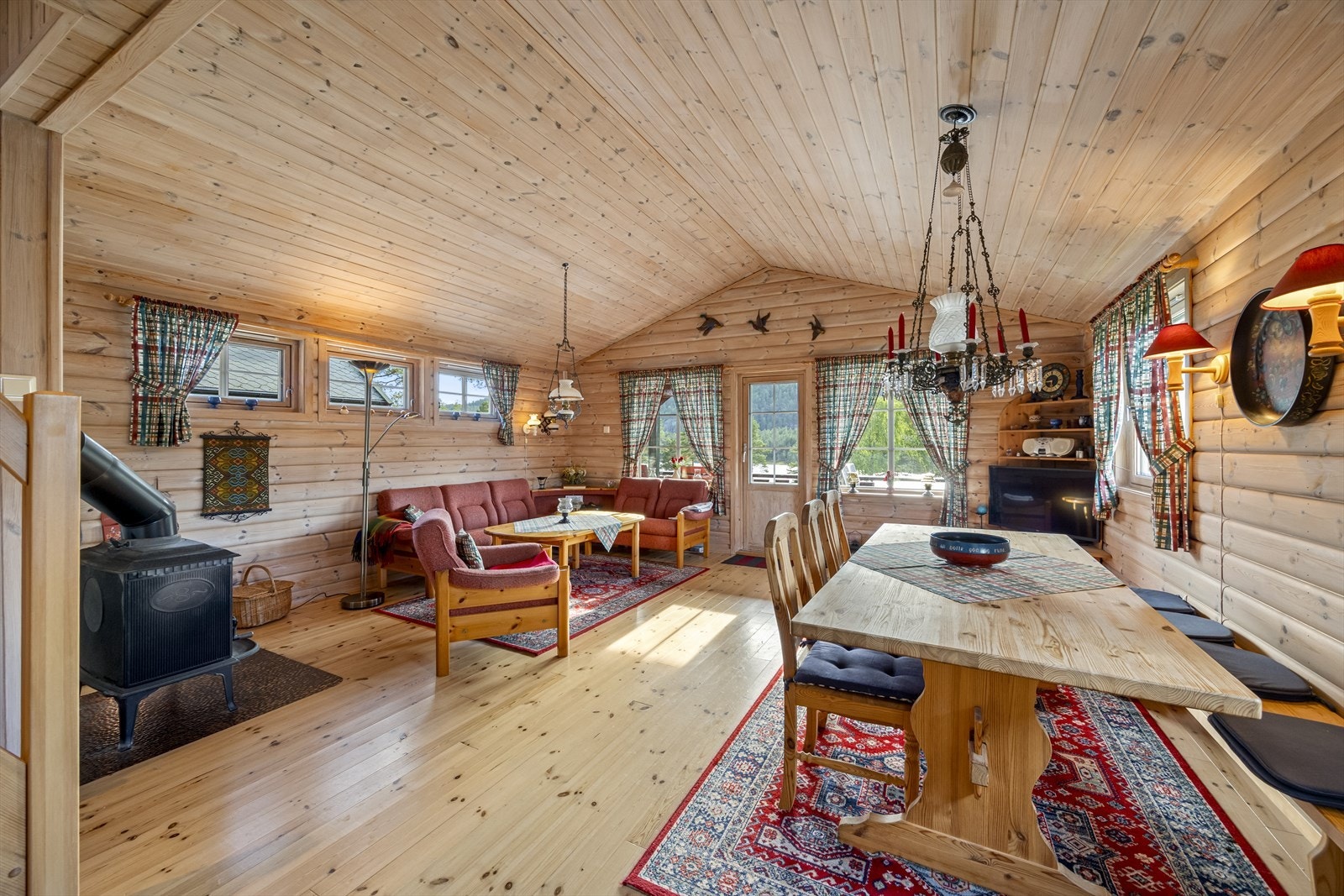 Koselig stue med gode møbleringsmuligheter, plass til sofagruppe og peiskos. Store vindusflater gir fantastisk utsikt og slipper naturen inn. Utgang til den store terrassen. Galleribilde