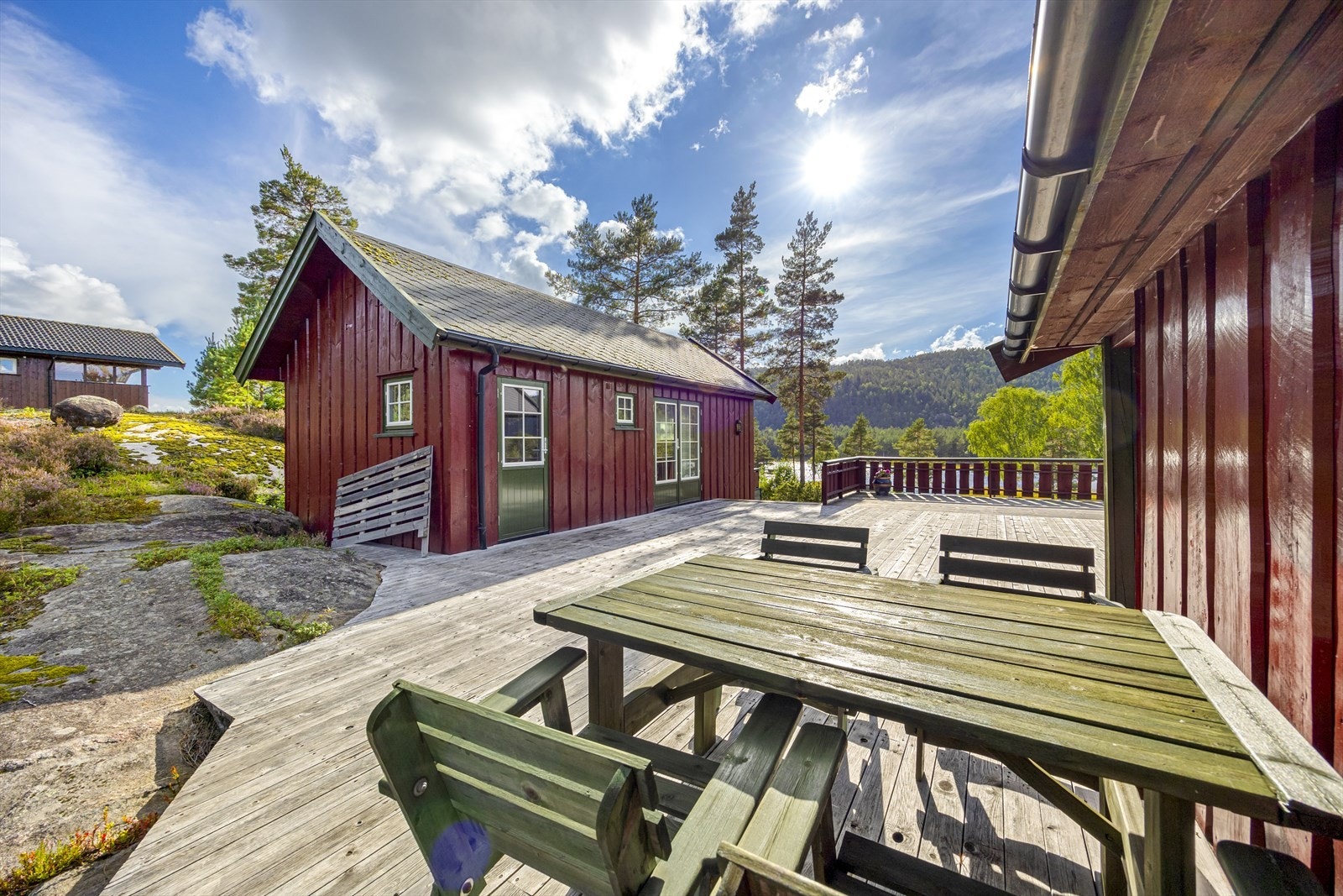 Den store terrassen binder sammen hovedhytte og anneks. Rikelig med plass til sittegrupper og utemøbler - perfekt for sosiale sammenkomster. Galleribilde